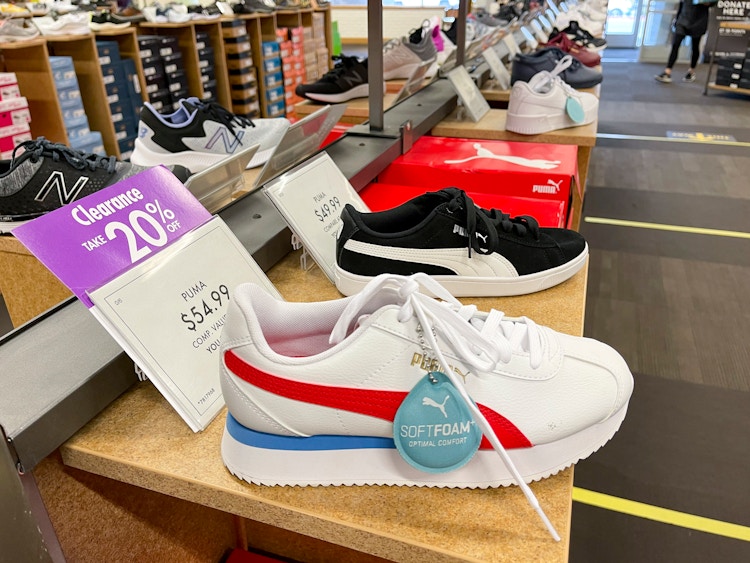 A row of shoes for sale with a purple sign next to one of them that says "Clearance, 20% off