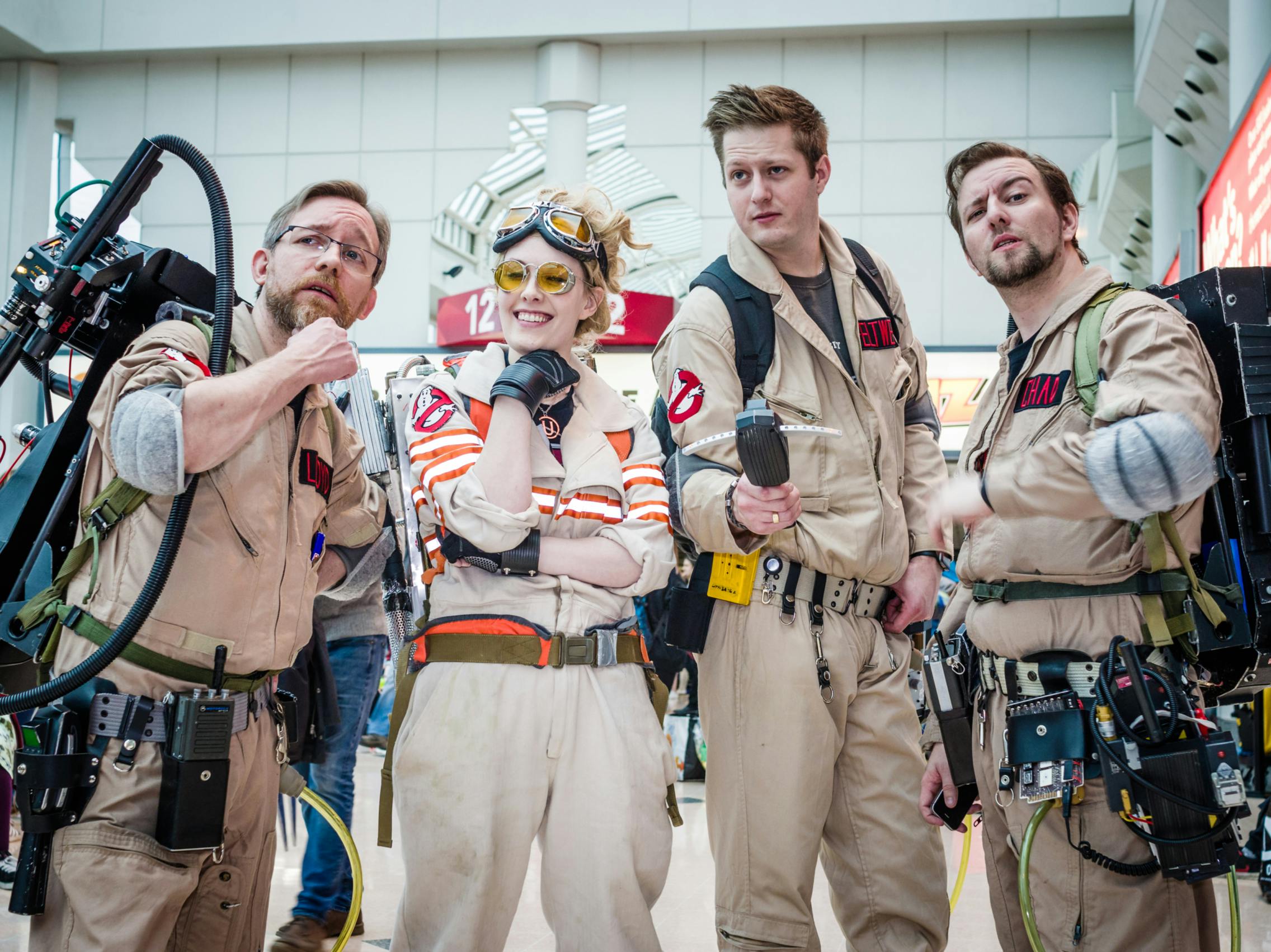 A group of people dressed in Ghostbusters costumes at a comic convention.