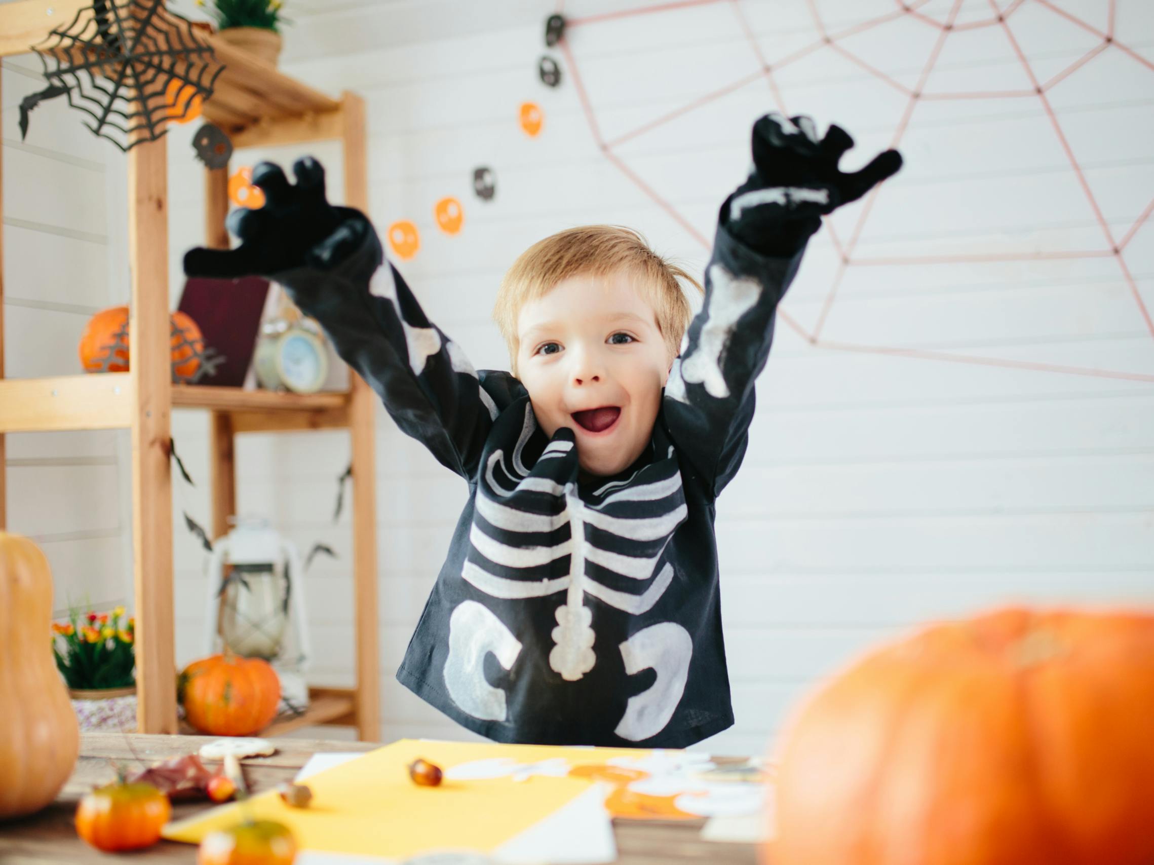 A little boy dressed as a skeleton making a funny face