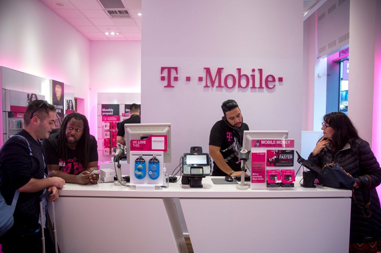A t-mobile customer counter with employees helping customers.