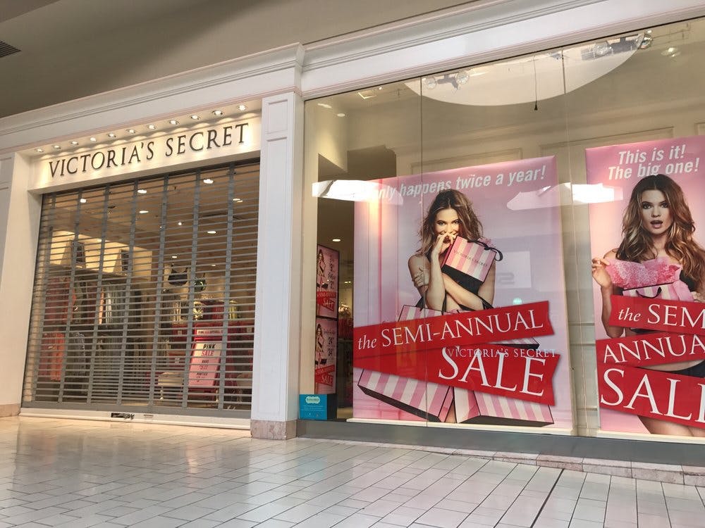 Victoria secret location in a mall with gates closed in front of it and semi-annual sale signs in the window