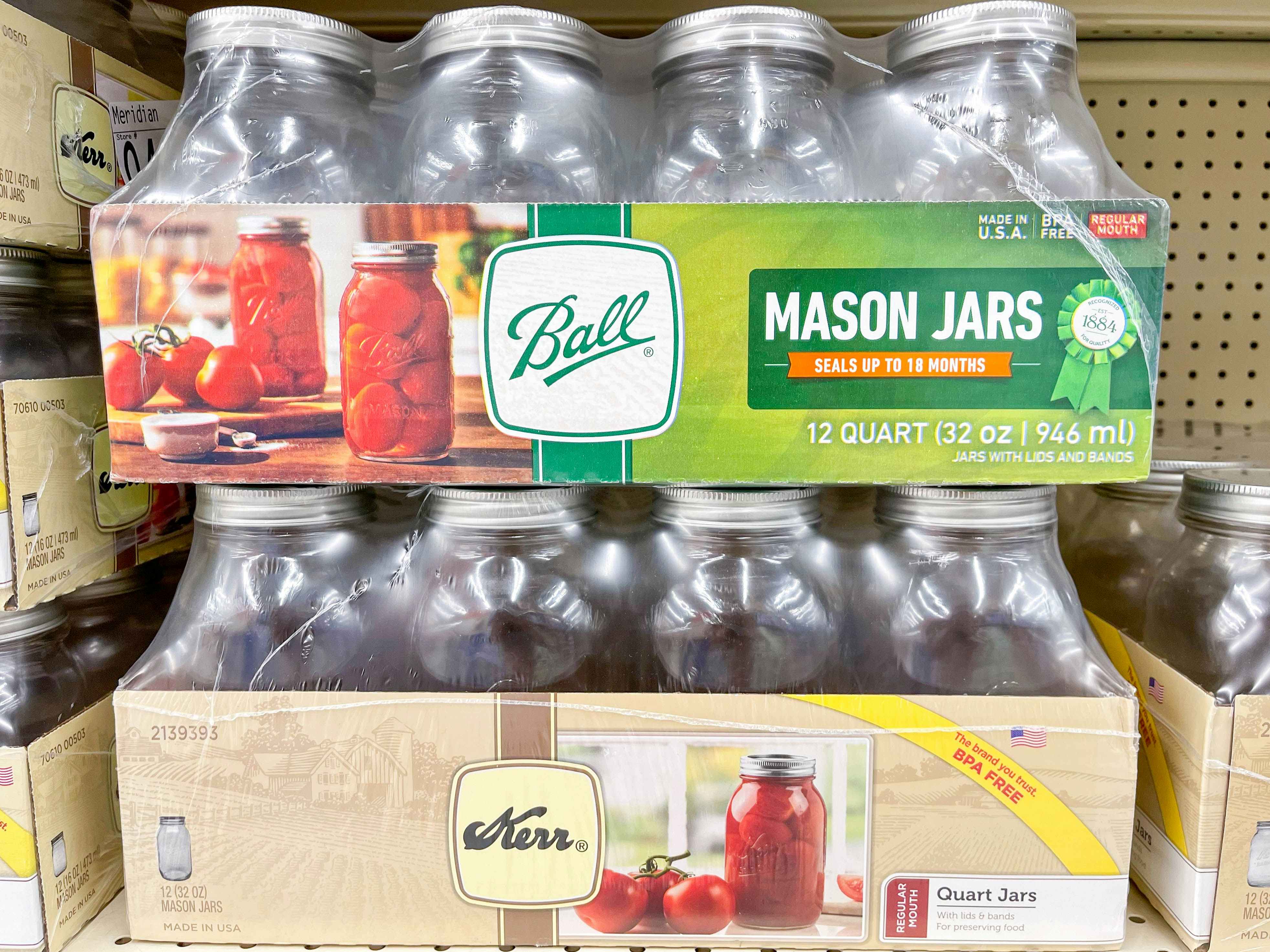 A case of 12 Ball canning jars on top of a case of 12 Kerr canning jars on a shelf in a store.
