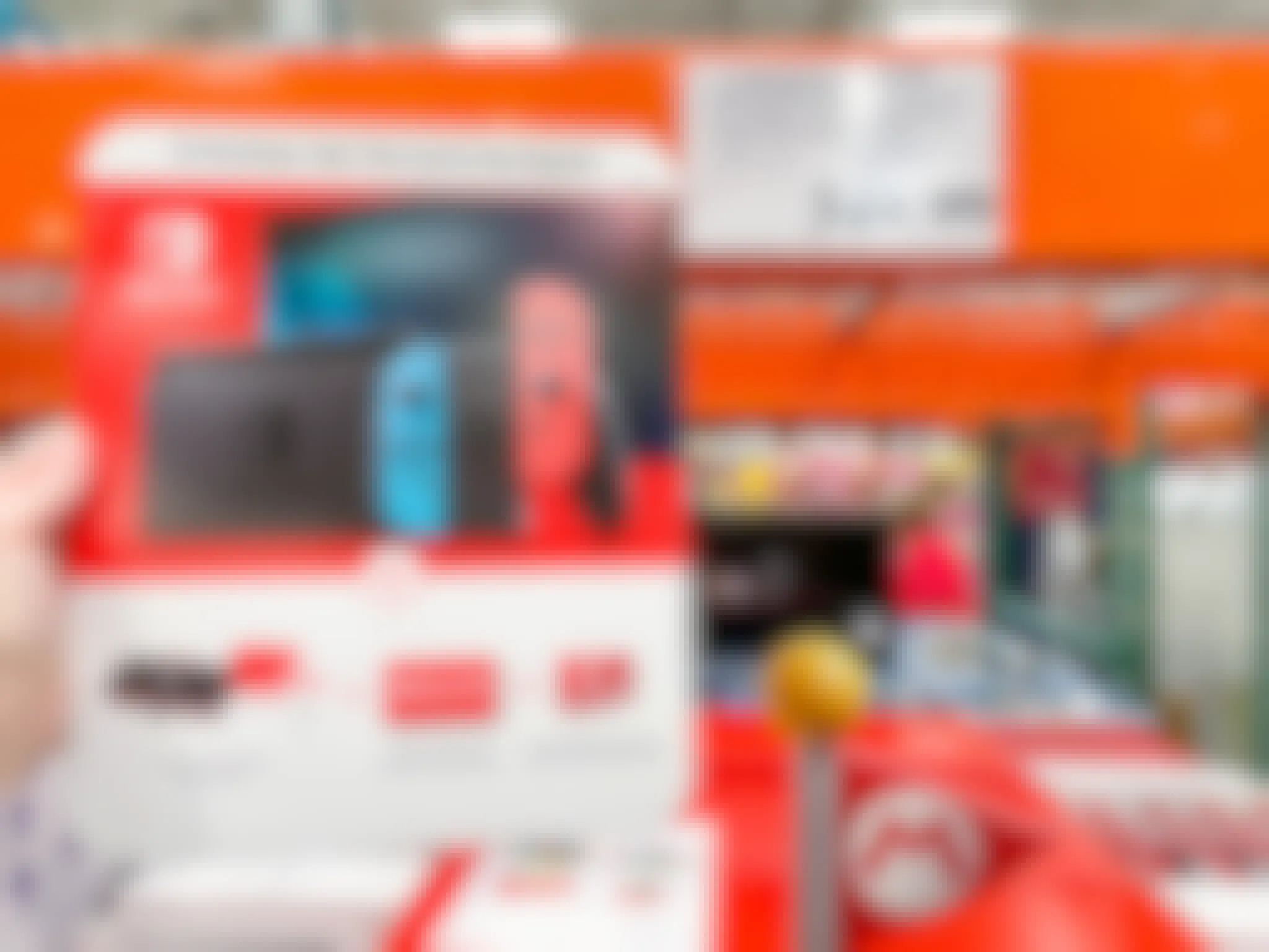 A Nintendo Switch Bundle being held up in front of the price sign at Costco.