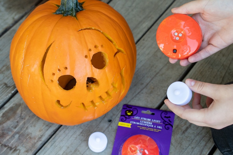 Battery operated tea lights held next to a pumpkin