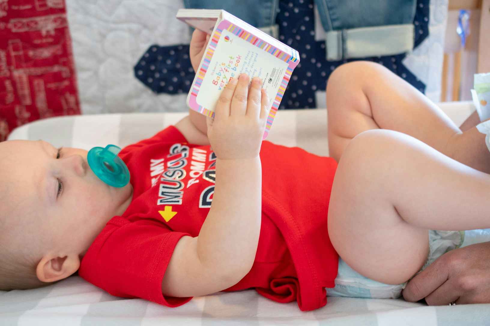 infant looking at board book during diaper change