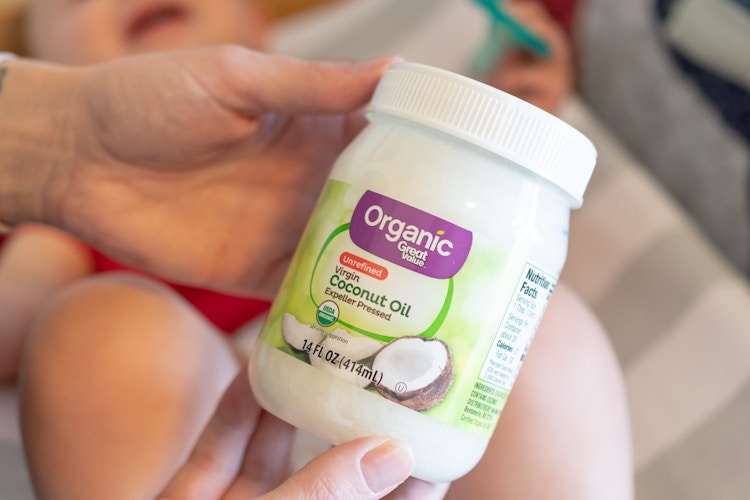 person holding bottle of organic coconut oil