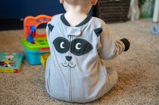baby wearing backwards pajamas playing with toys