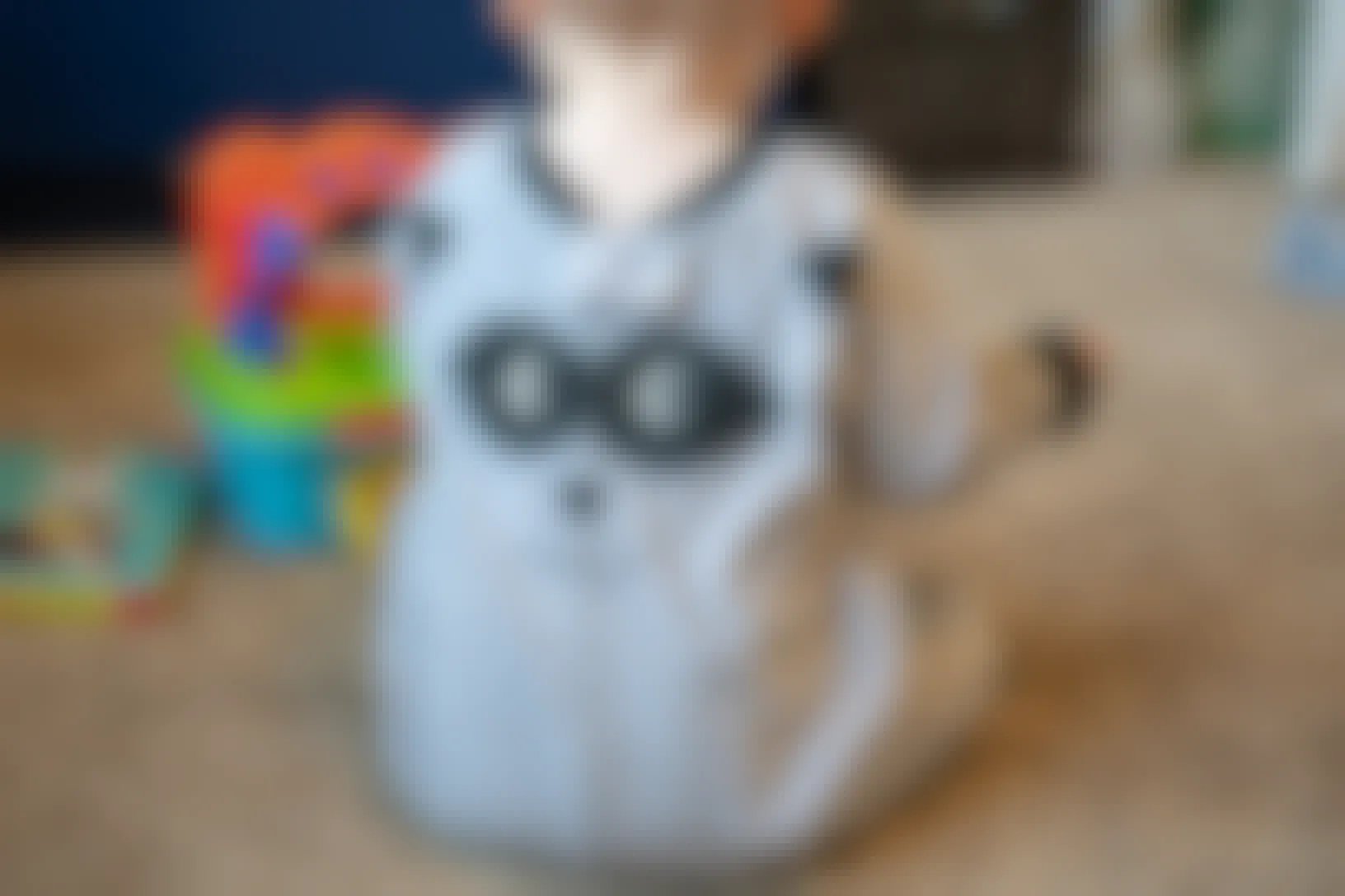 baby wearing backwards pajamas playing with toys