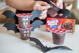 Chocolate pudding cups decorated to look like little bats with with googly eyes, construction paper bat wings, and yellow foam triangles for fangs.