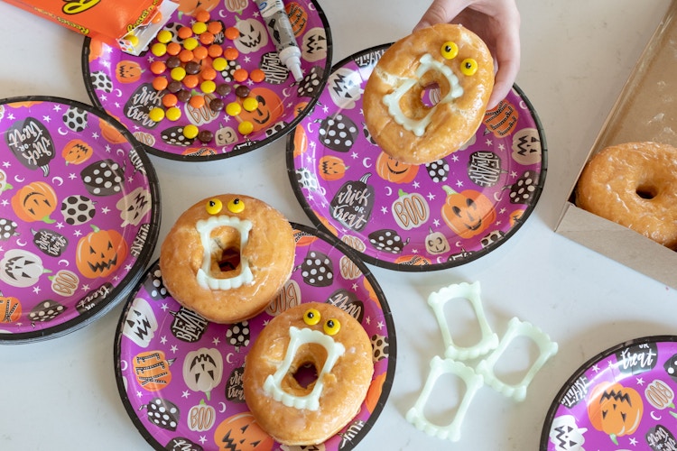 Donuts with vampire teeth in the center and candy Reeses pieces for the eyes