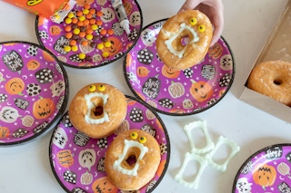 Donuts with vampire teeth in the center and candy Reeses pieces for the eyes