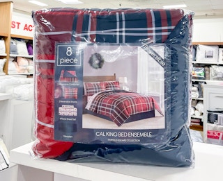 An 8-piece red and blue comforter set on a shelf at Macy's.