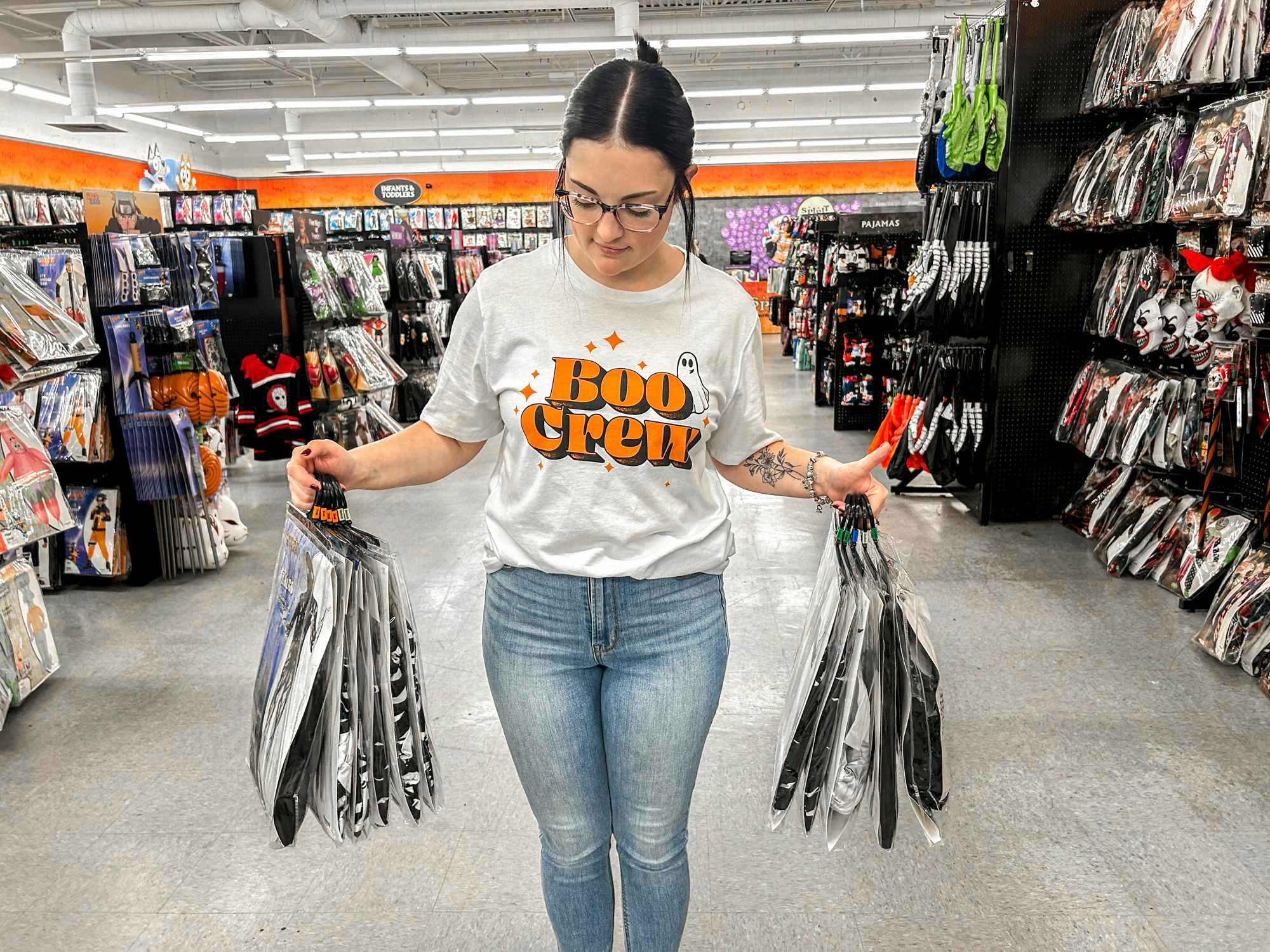 a person holding up spirit halloween costumes 