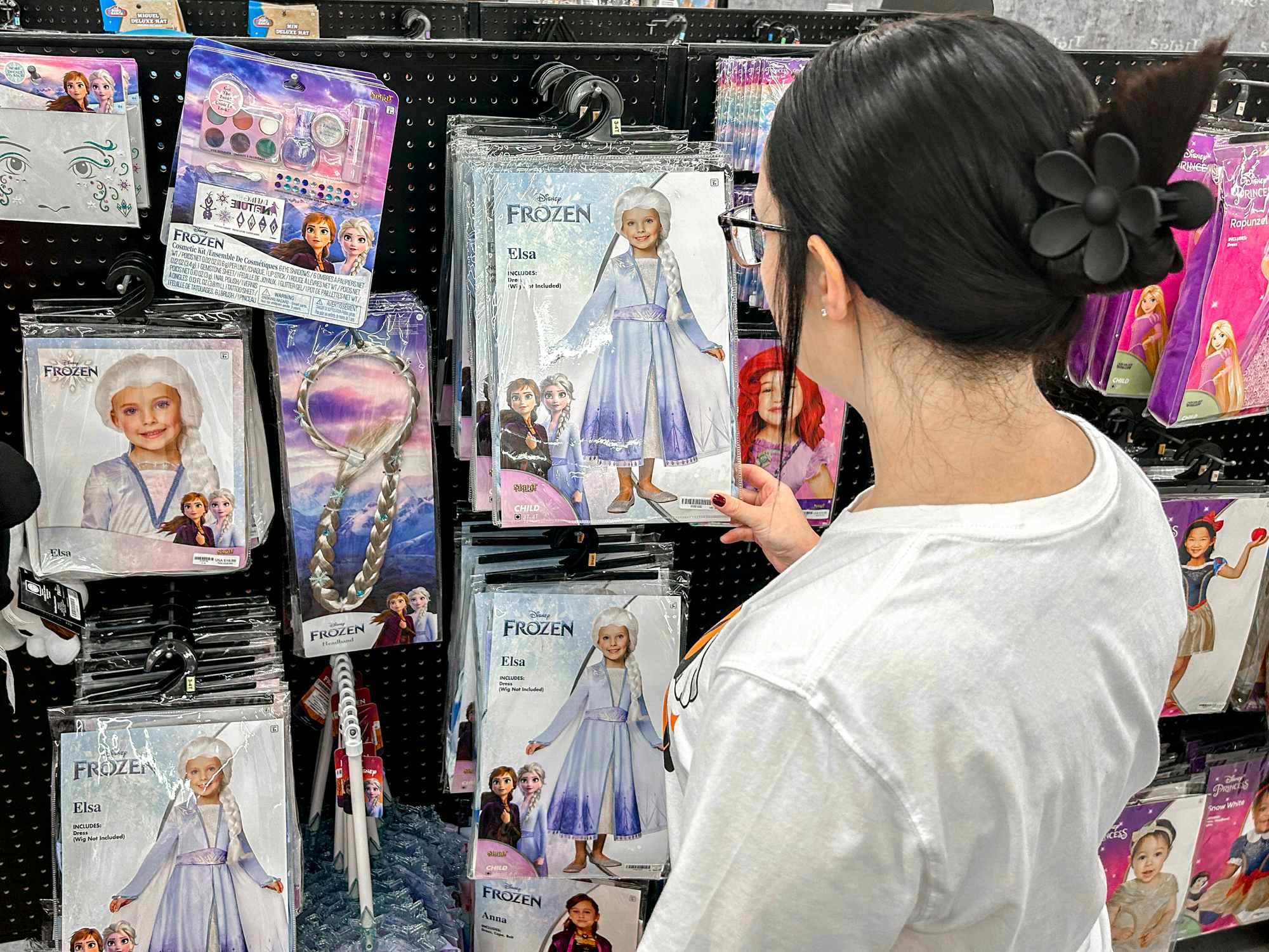 a person looking at the elsa costumes at spirit halloween 