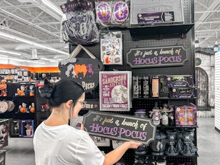 a person looking at the hocus pocus section in spirit halloween