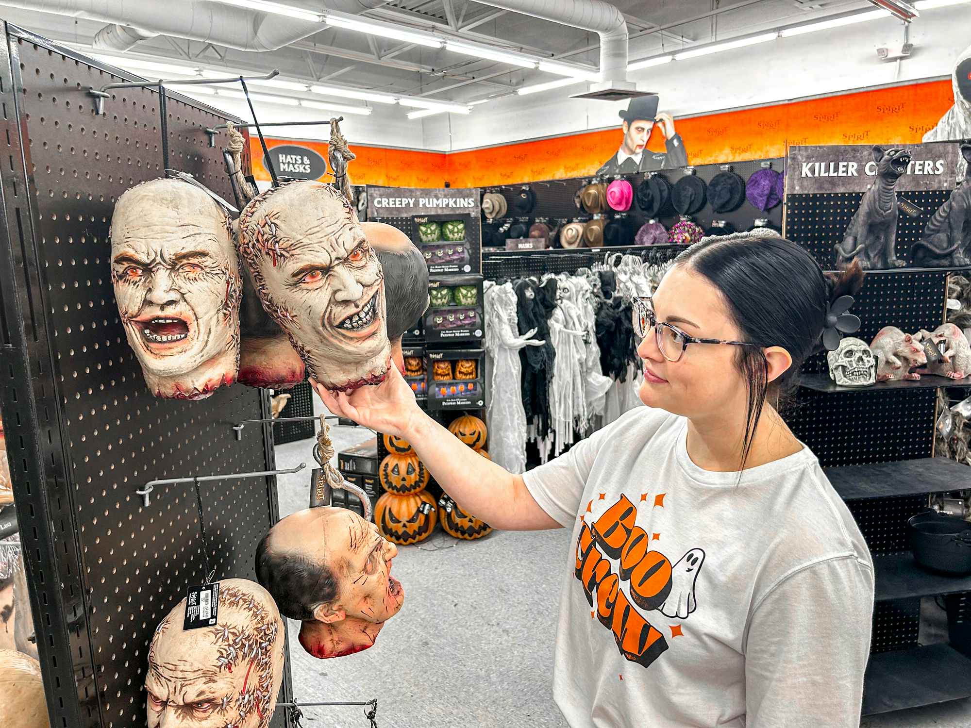 a person holding up a spirit halloween zombie head