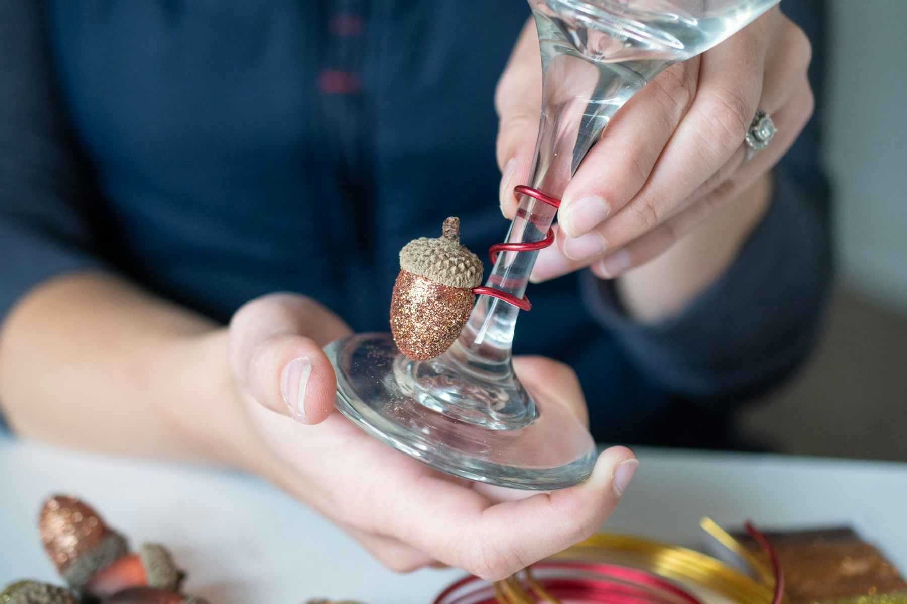 A wine glass with a homemade acorn charm on the bottom.