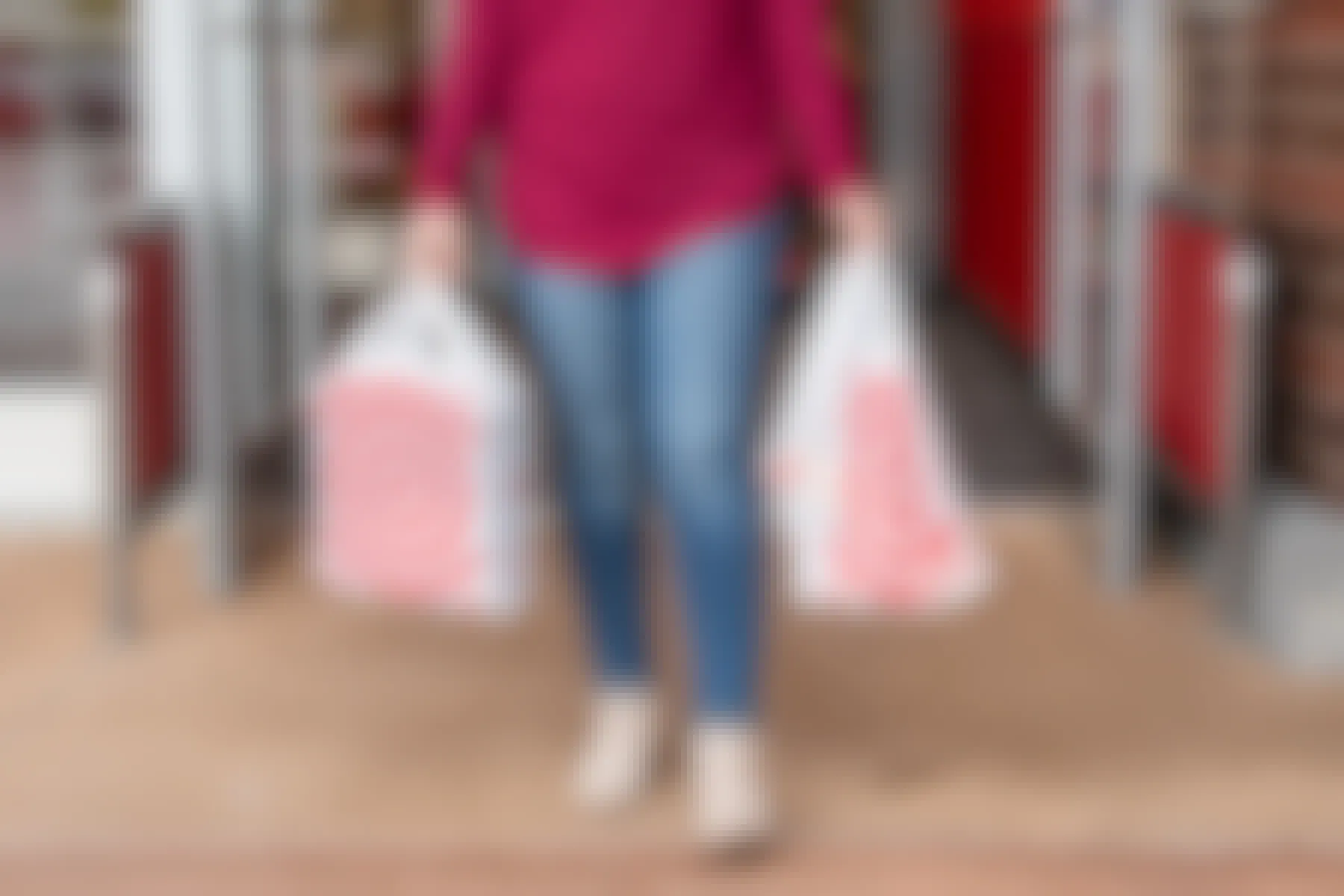 Woman walking out of a Target store with bags in both hands.