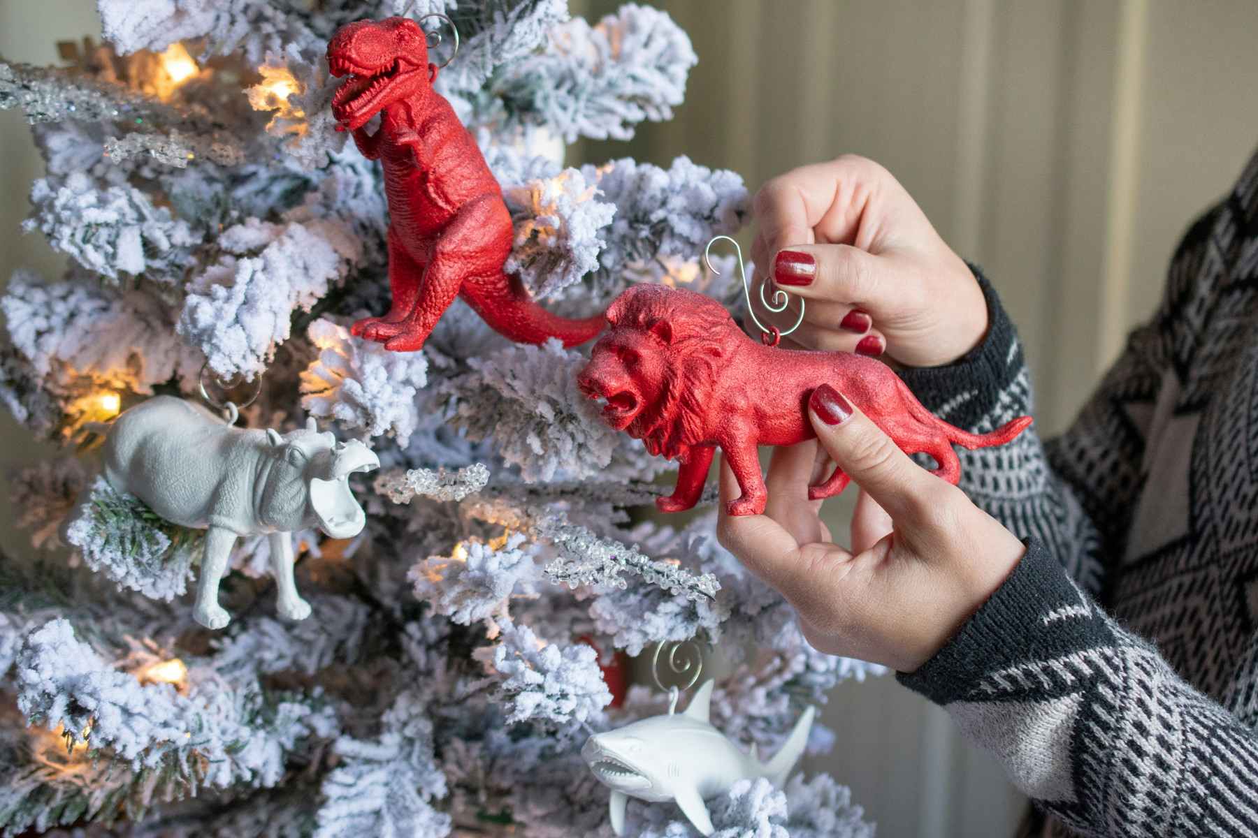 someone hanging a toy tiger painted red on a tree