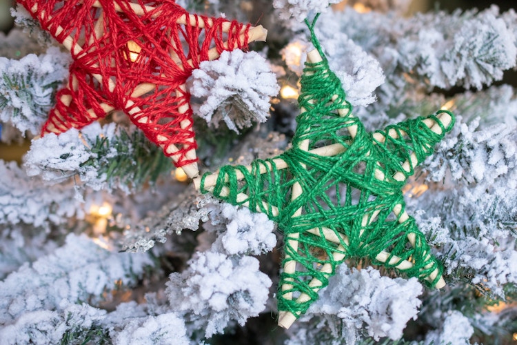 wooden star with string wrapped on it on a tree
