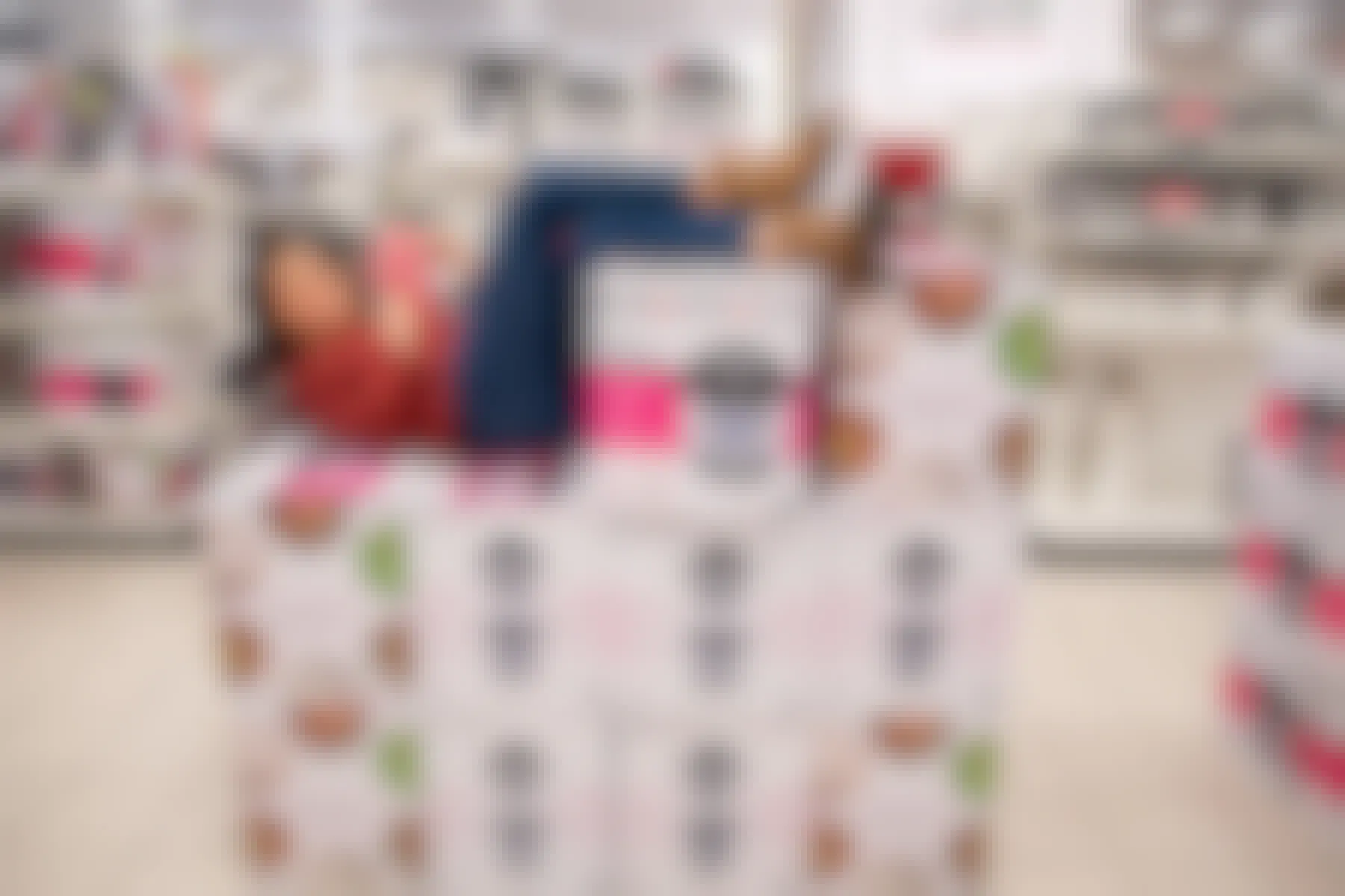 A woman laying on a pile of Instant Pot cookers on display for Black Friday deals at Kohl's.