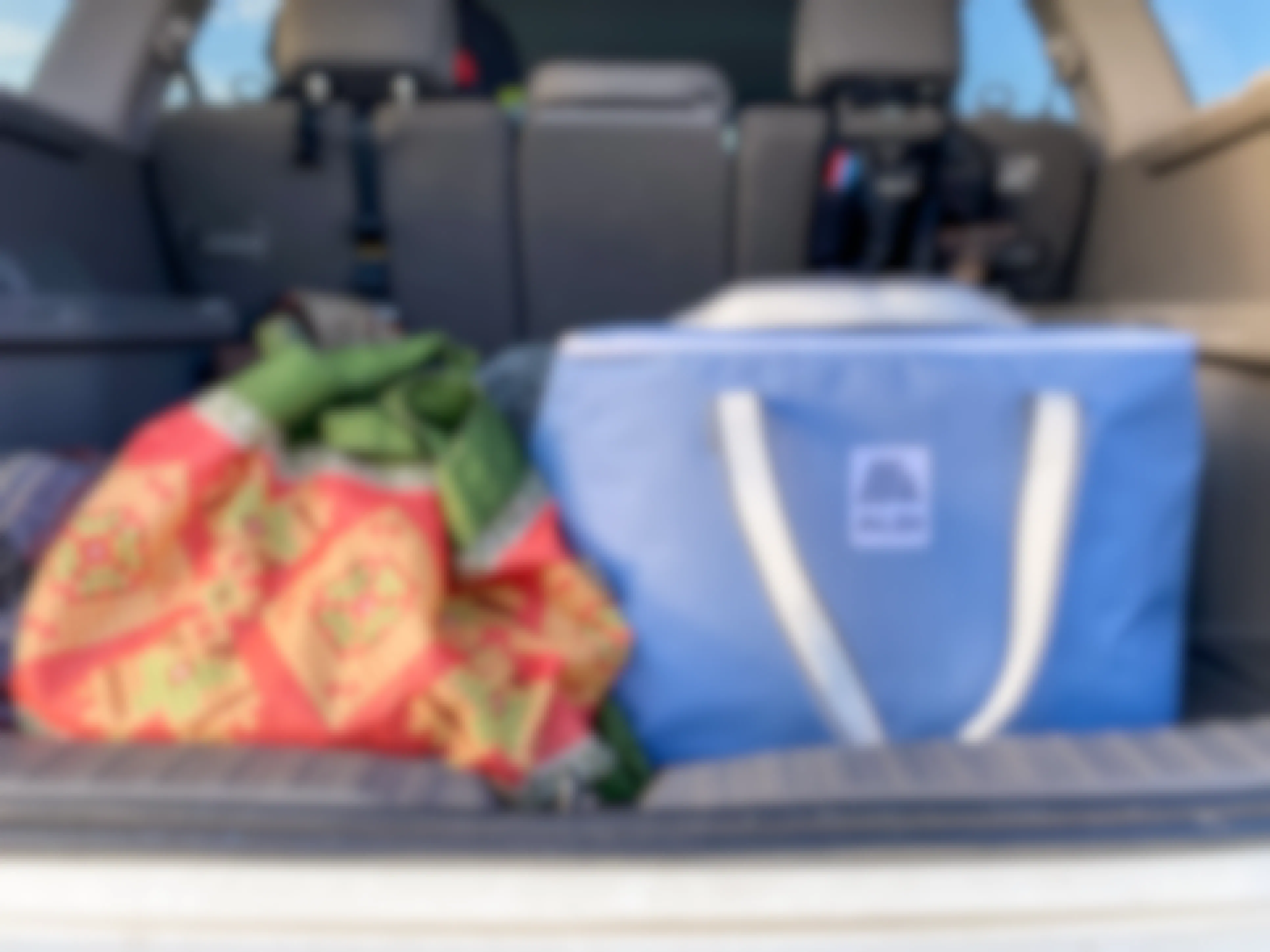 Some reusable shopping bags in the trunk of a vehicle.