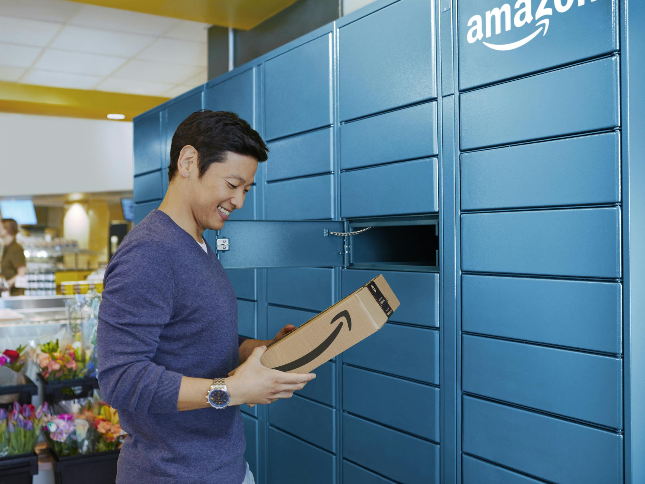 A person getting a package from an Amazon hub locker