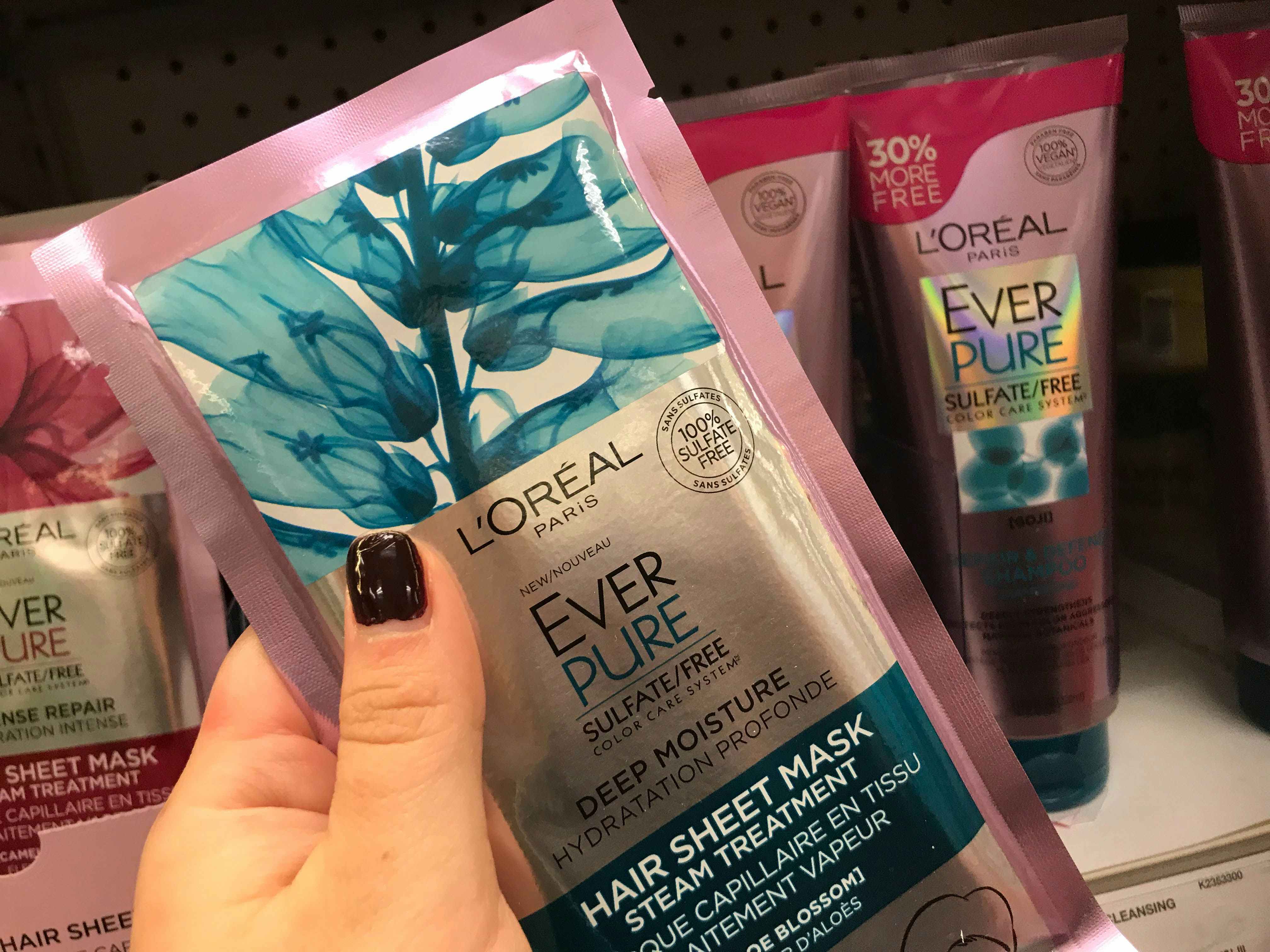 A person's hand holding a L'Oreal sheet mask.