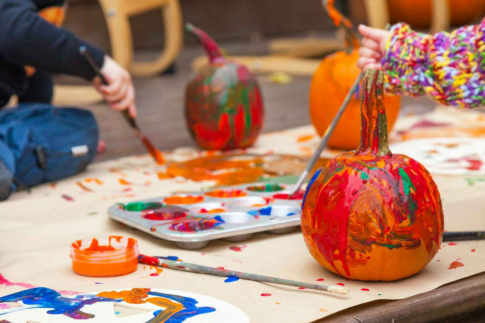 Children painting the outside of pumpkins 
