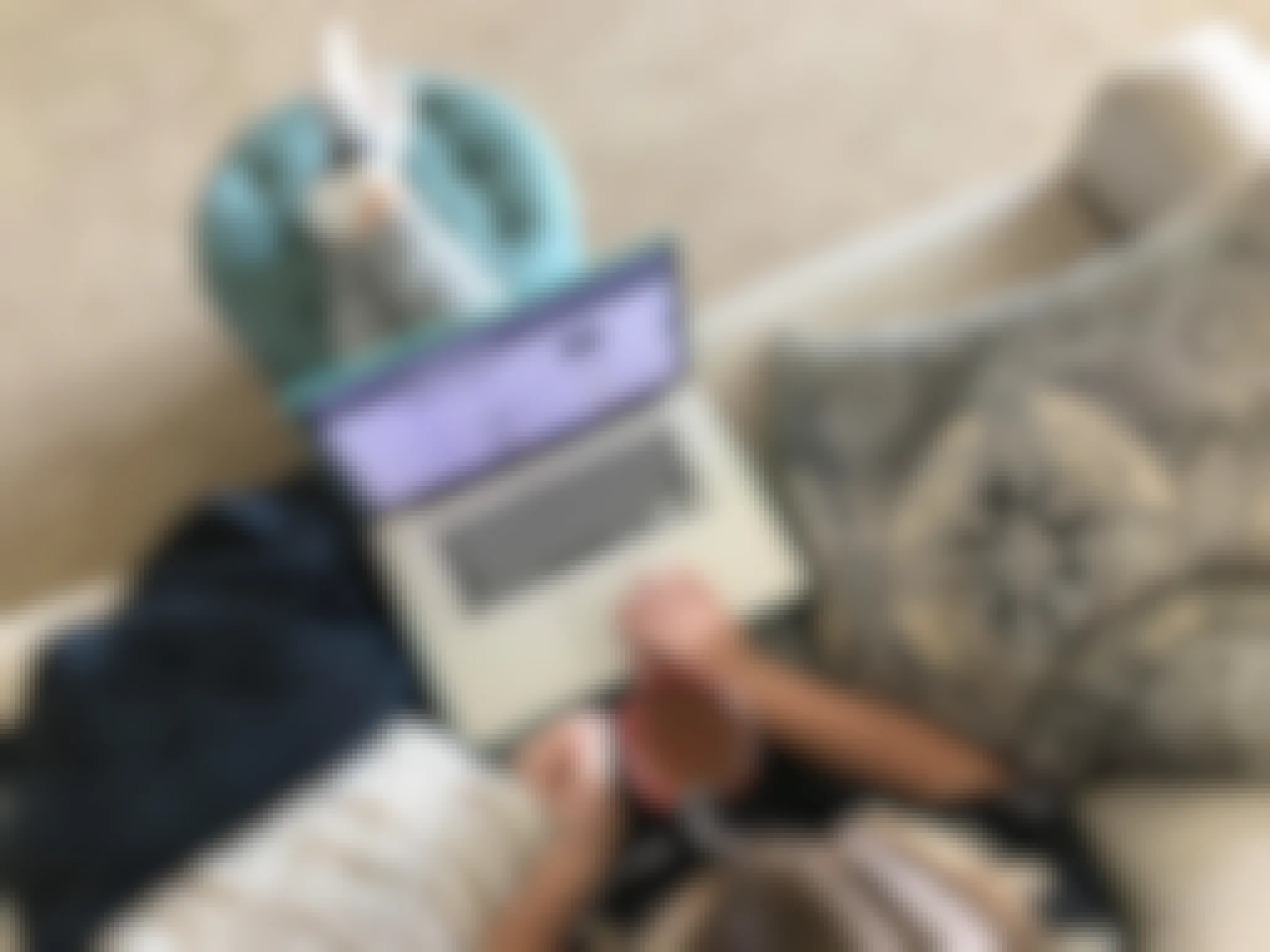 Someone sitting on a couch, drinking coffee and online shopping on a computer