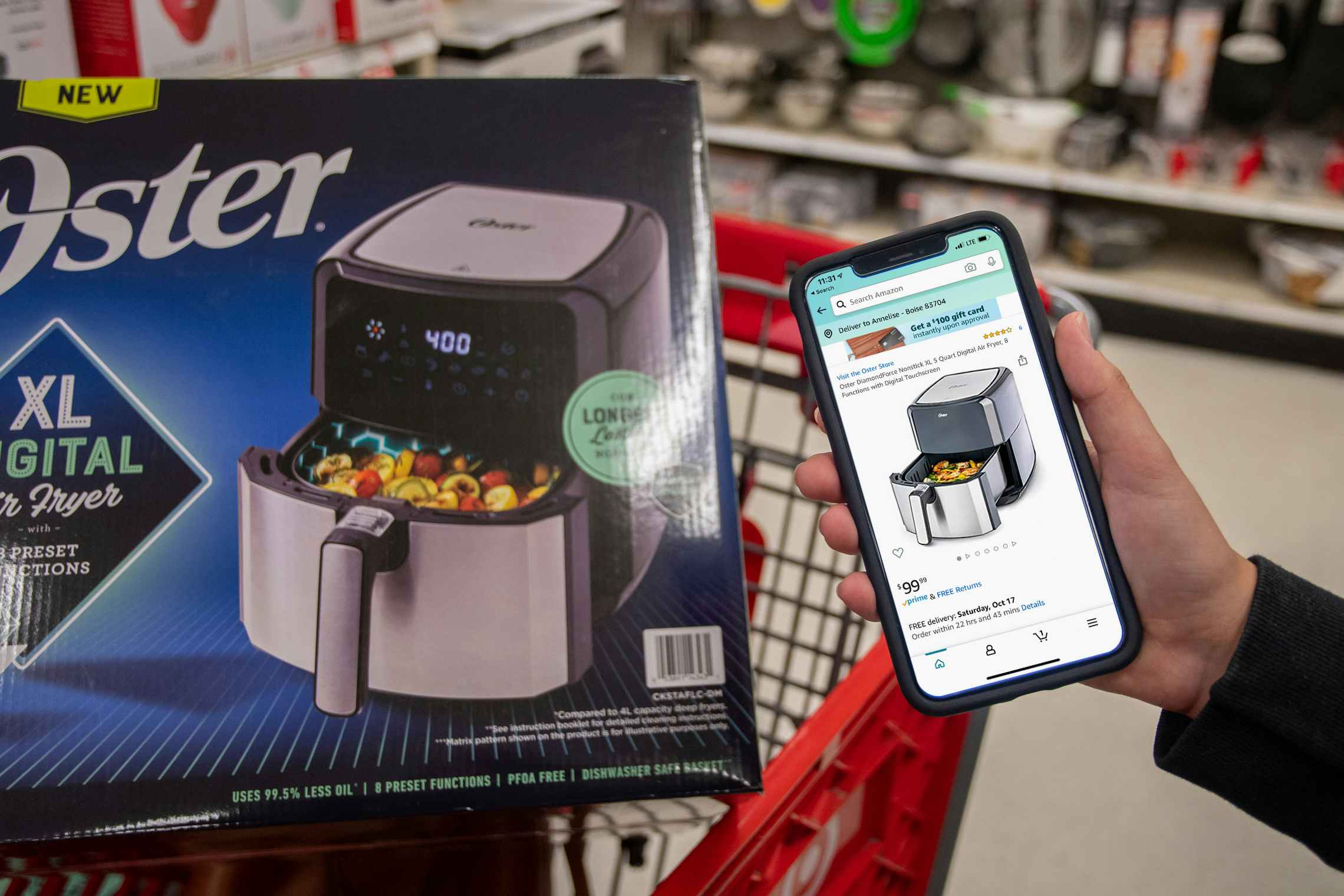 Amazon app held next to an air fryer in a target shopping cart.