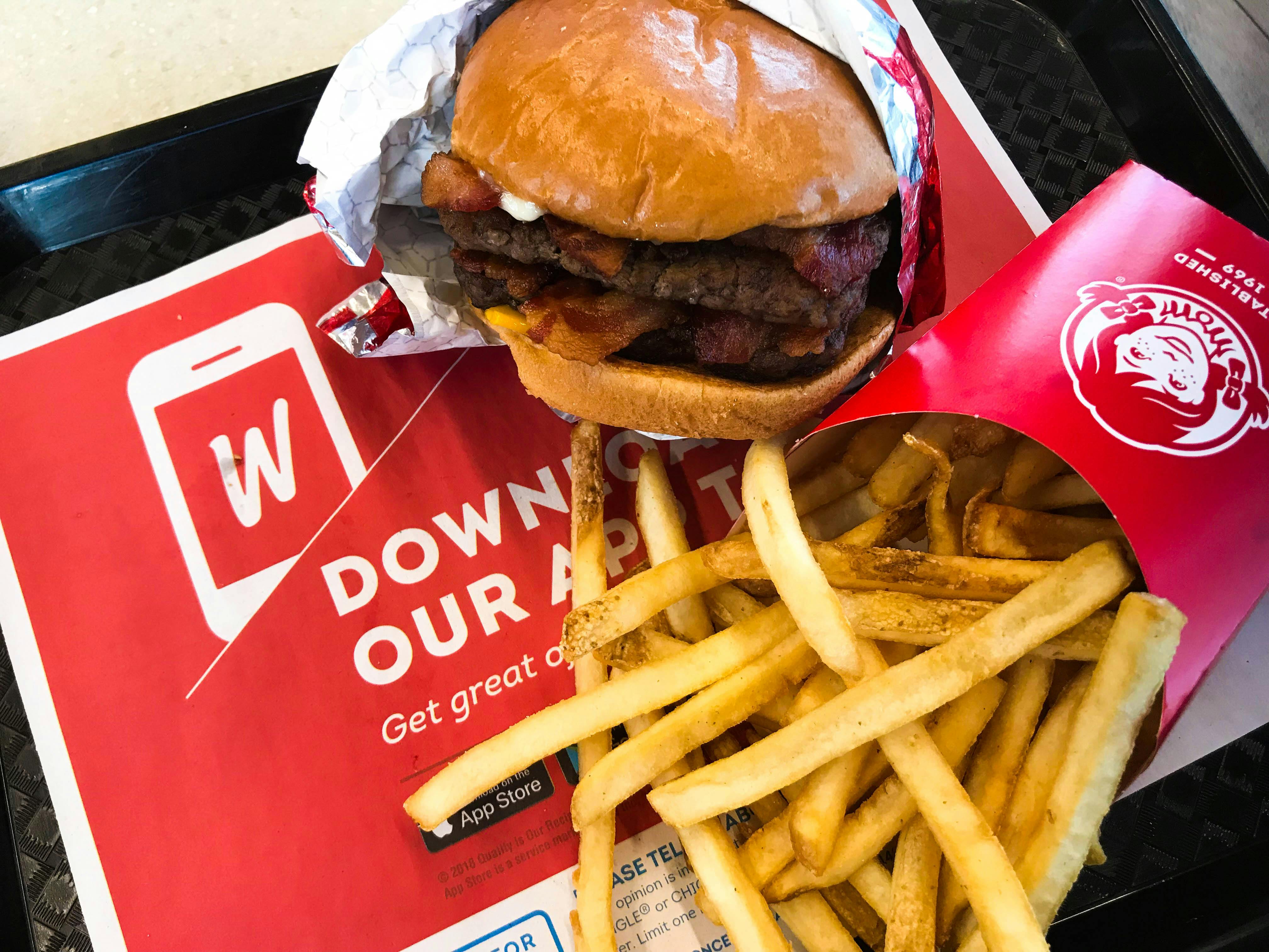 A Wendy's burger and fries on a tray at a table at Wendy's.