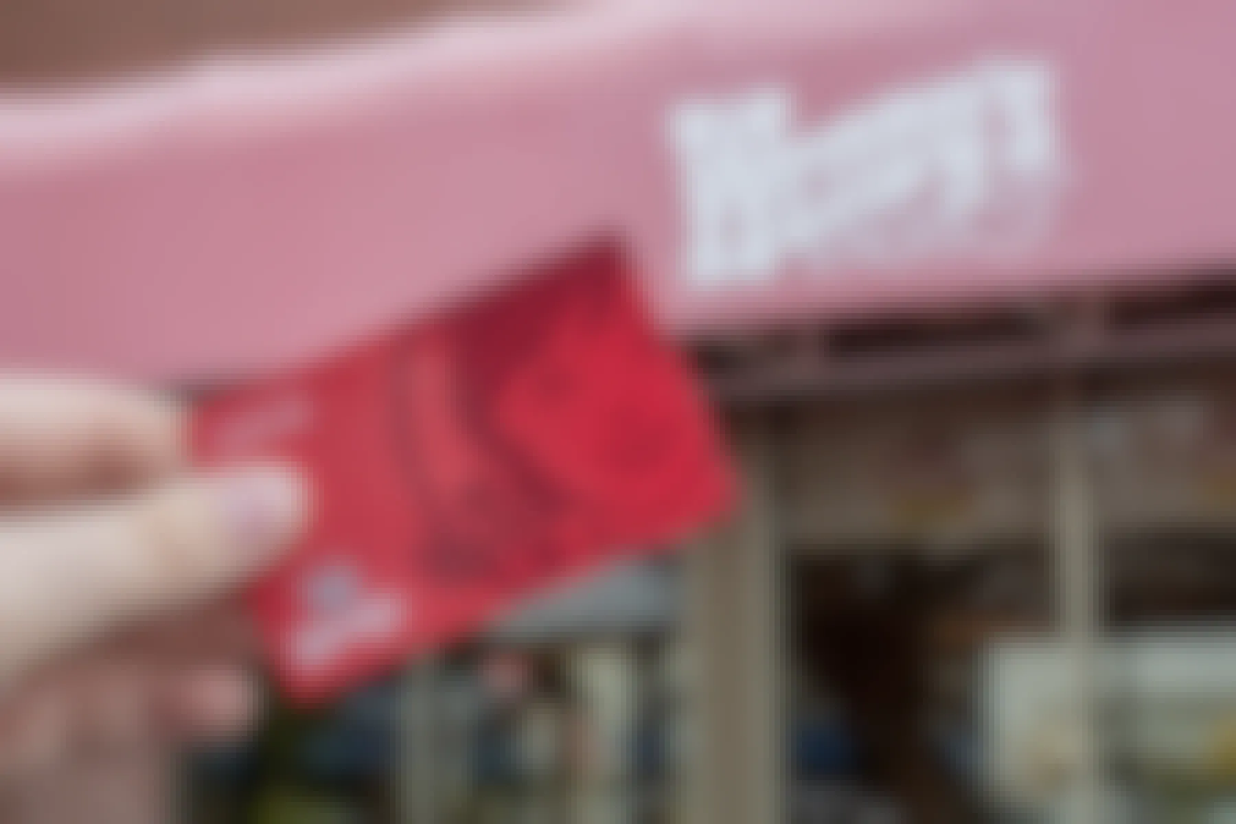 a wendys gift card being held in front of a wendys 