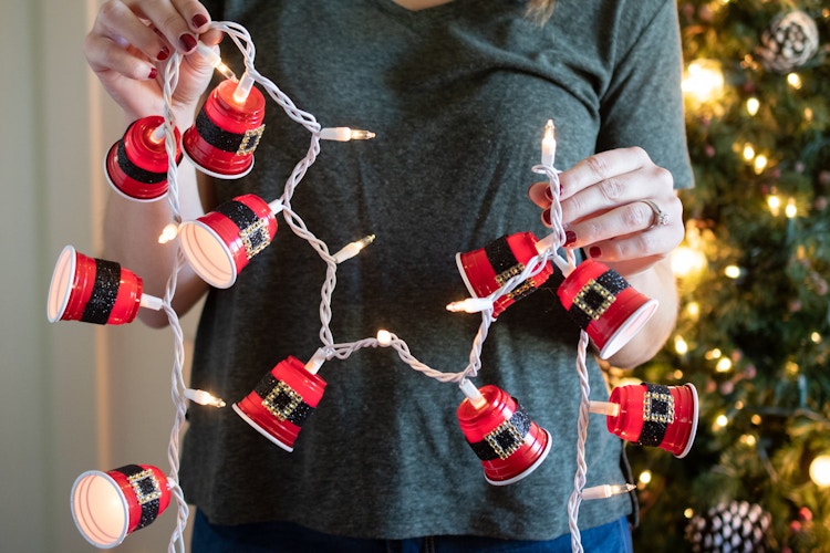 A strand of Christmas lights with DIY Santa, red party cups attached. 