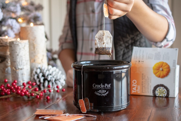 A tea bag held over a small crock-pot