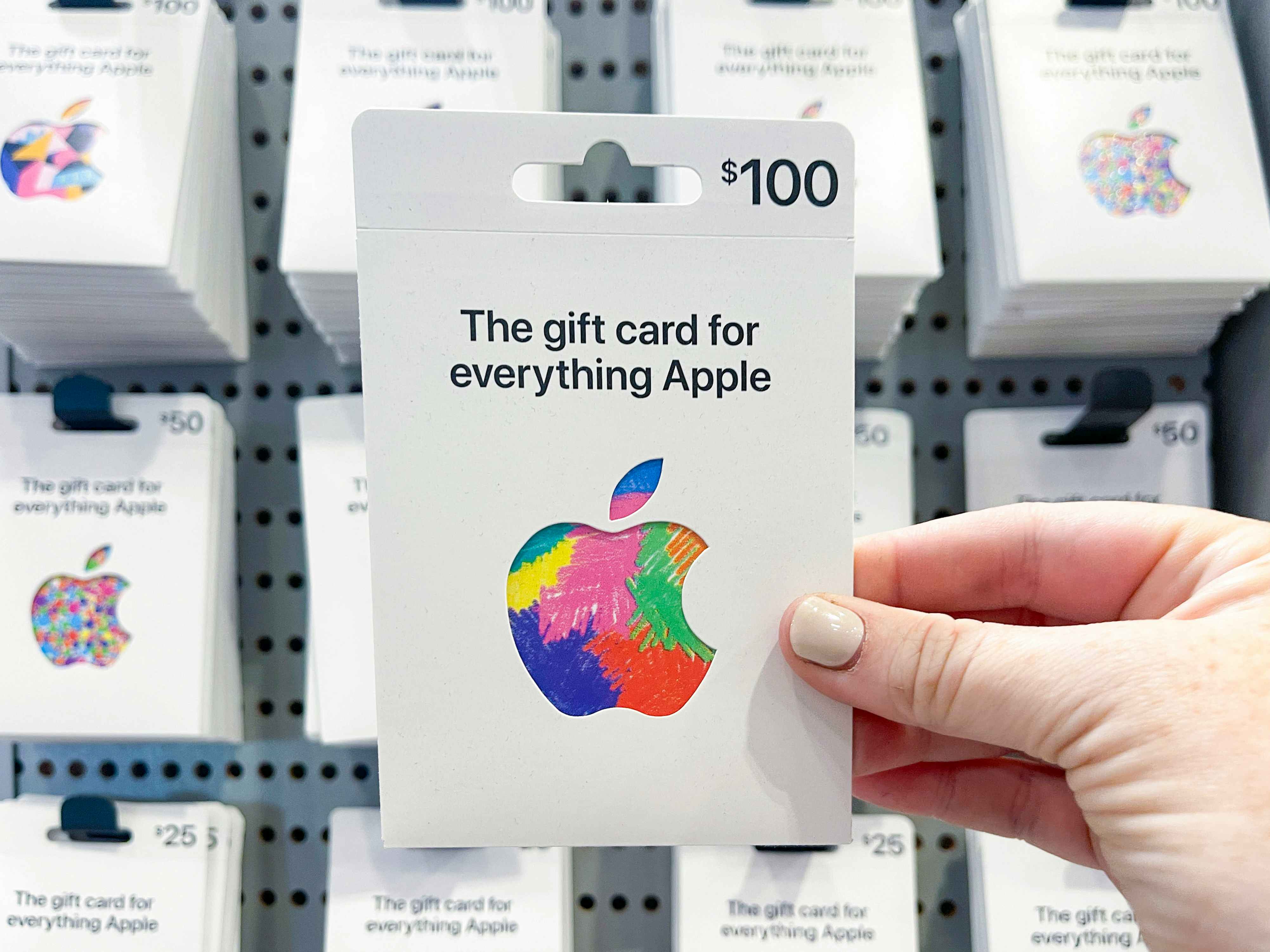 A person holding an apple gift card.