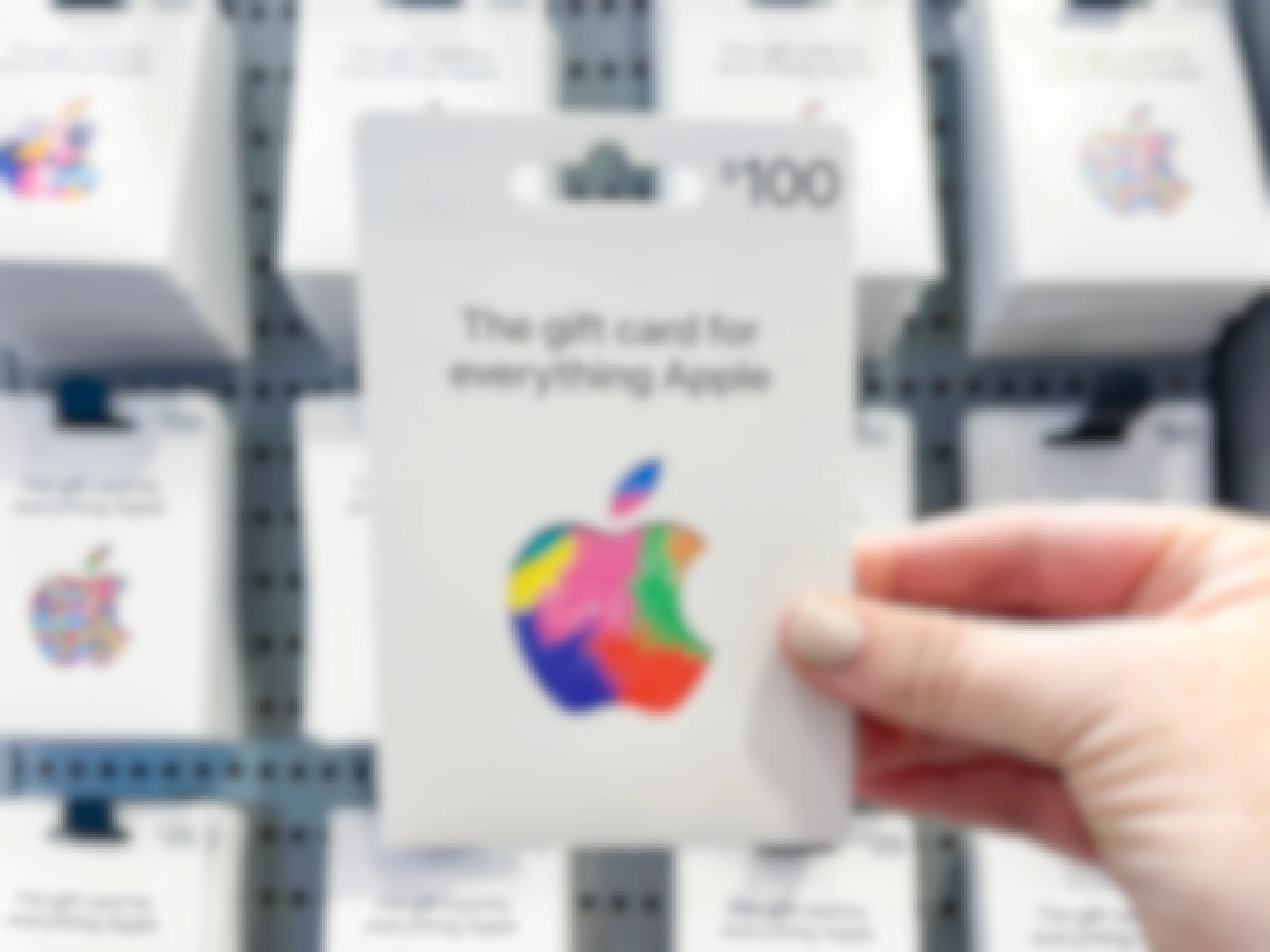A person holding an apple gift card.