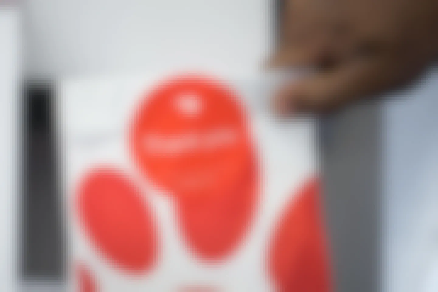 Image of a hand holding a to-go Chick-fil-A bag that says "Thank you