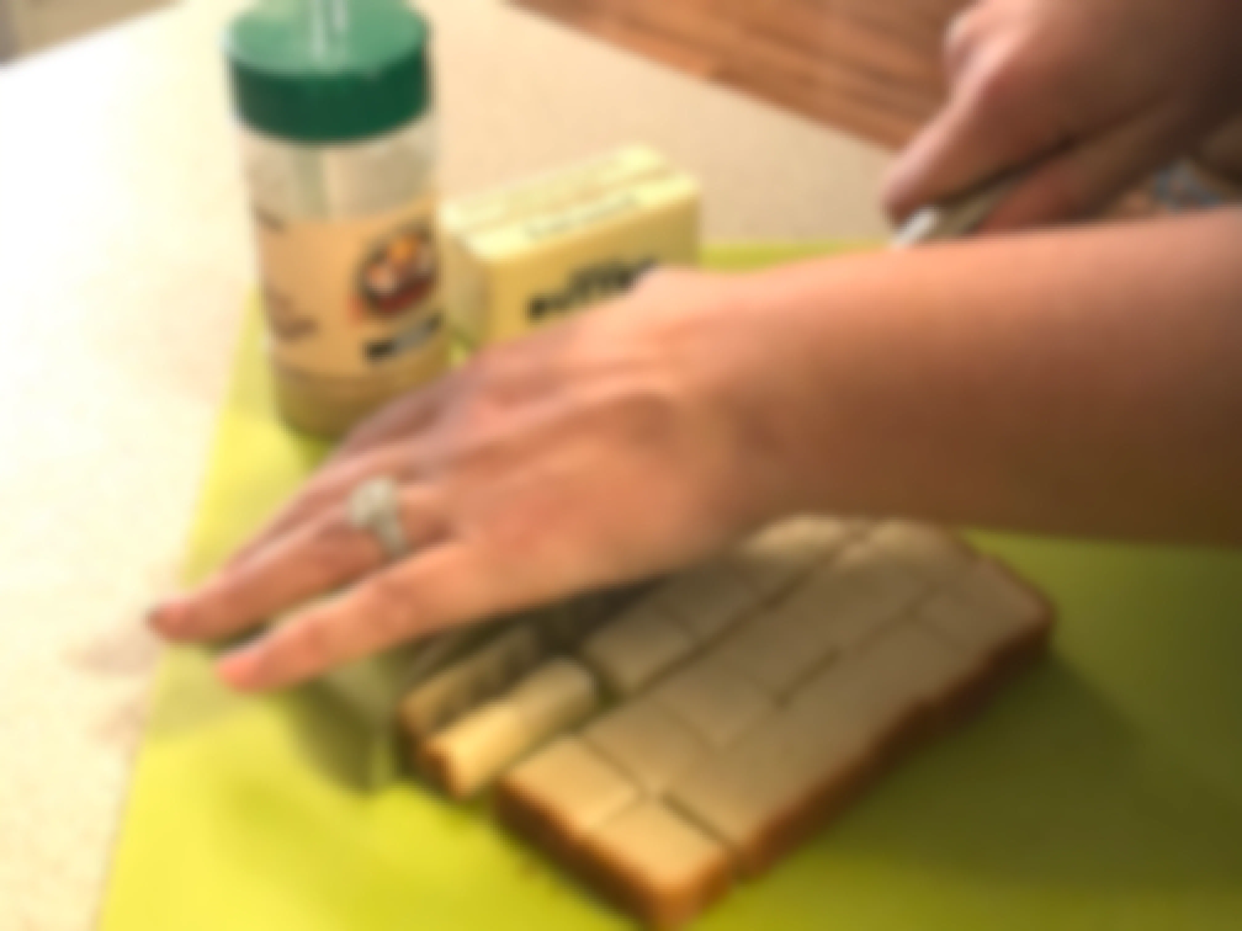 A person cutting up bread into cubes.