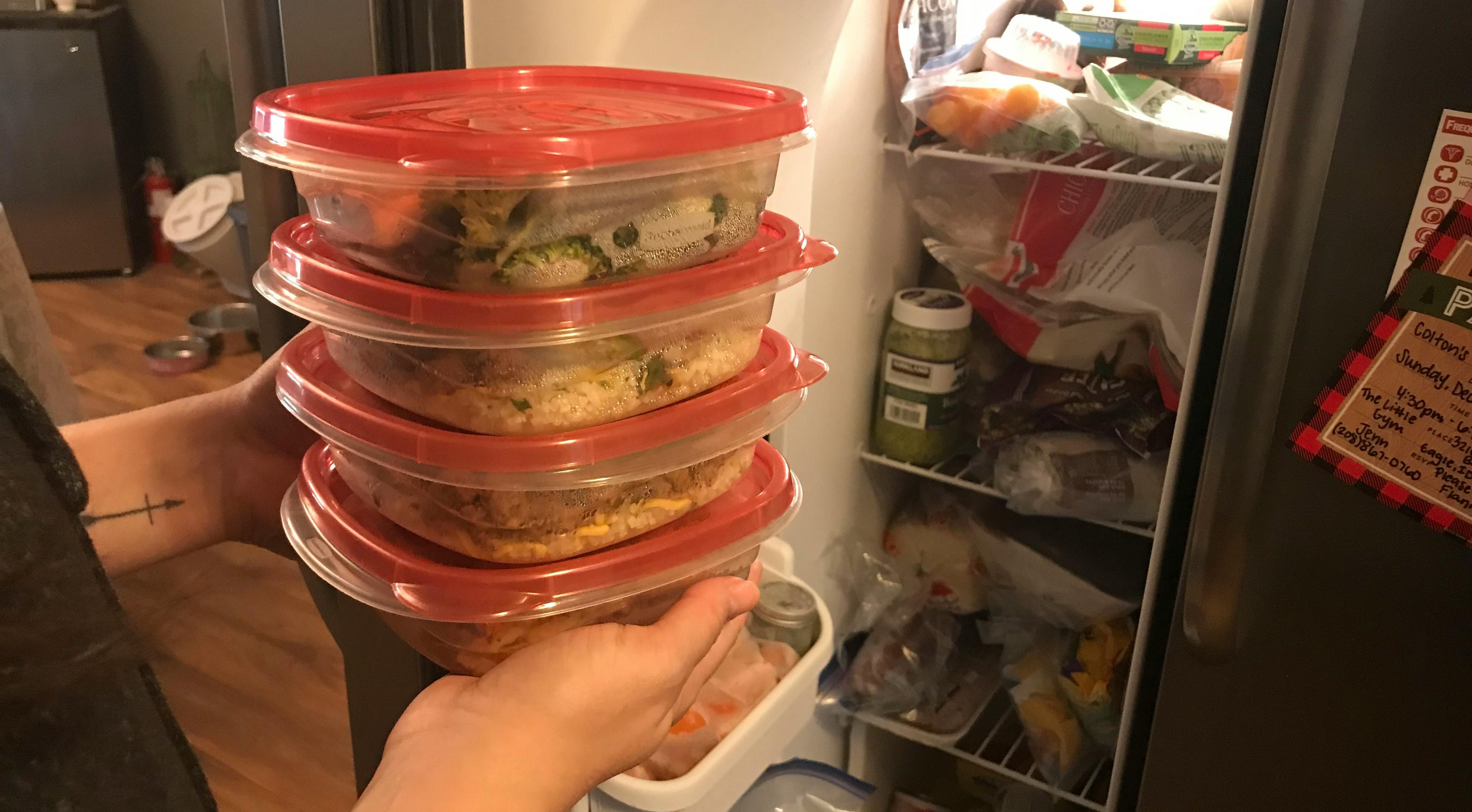 hand puts containers into freezer