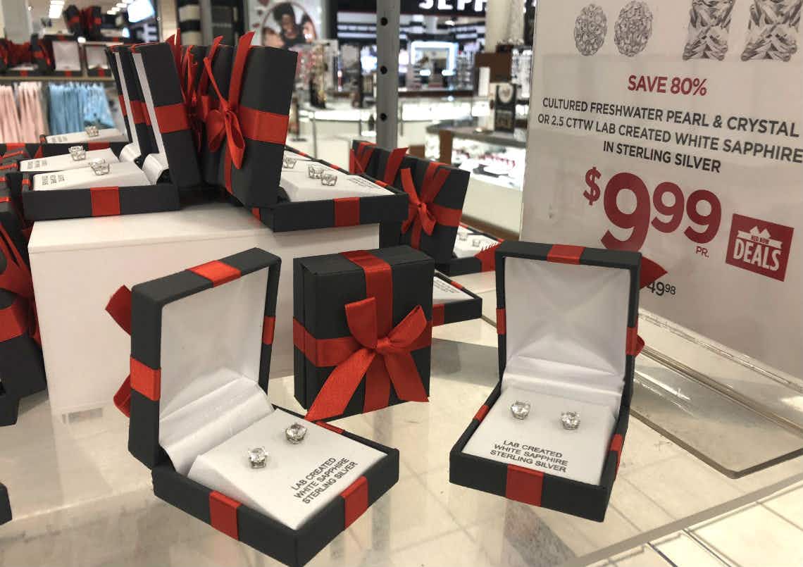 Two boxes of diamond stud earrings sitting on top of a store display.