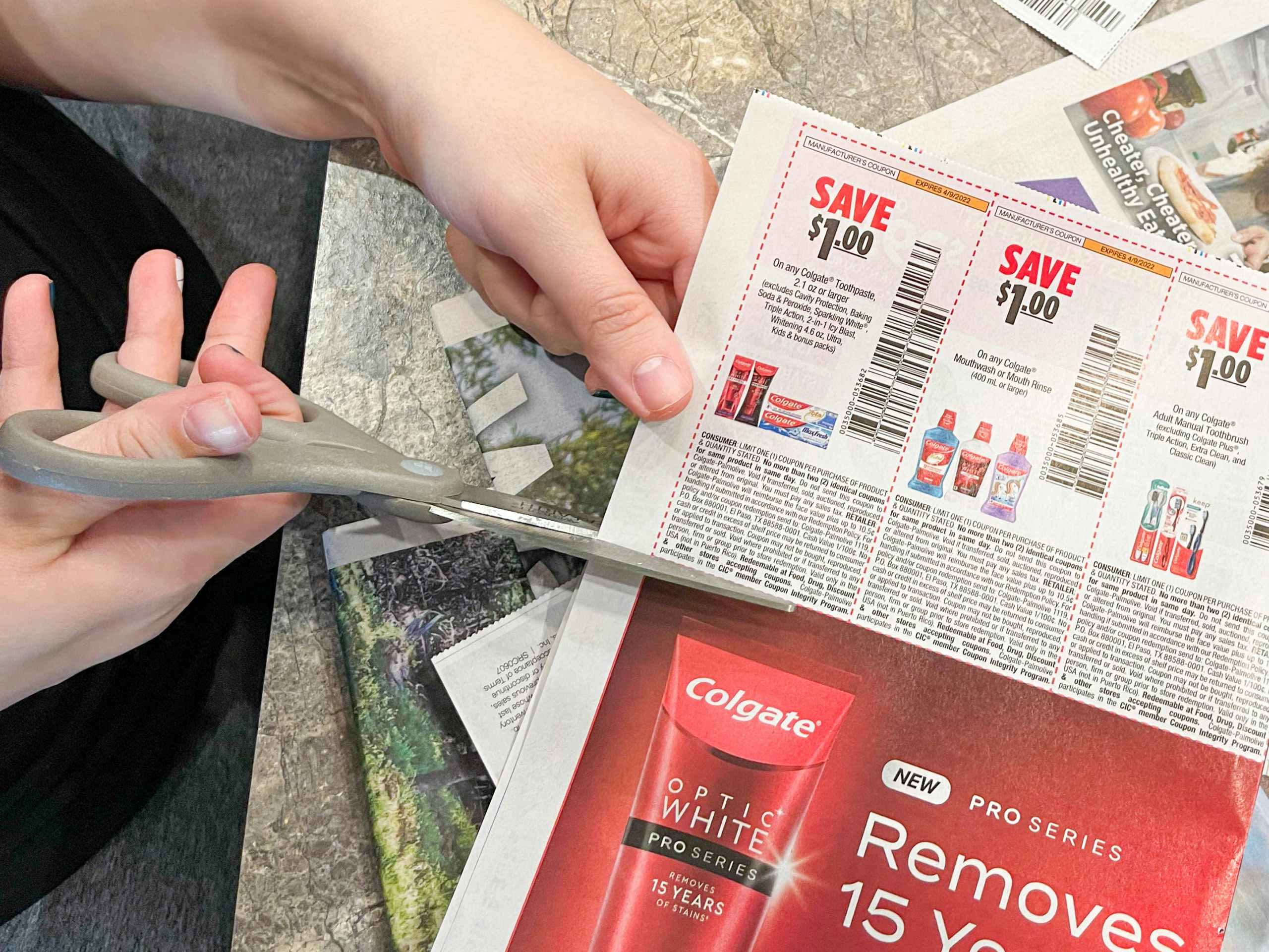 a person cutting coupon inset out of newspaper