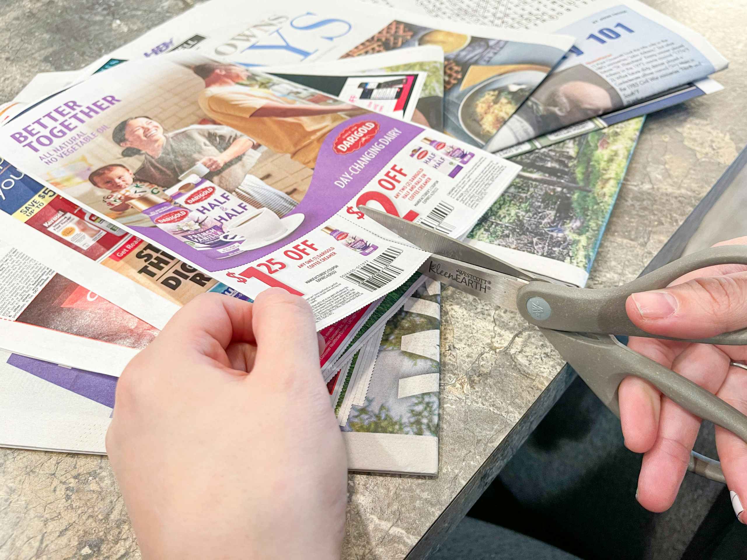 a person cutting coupon inset out of newspaper