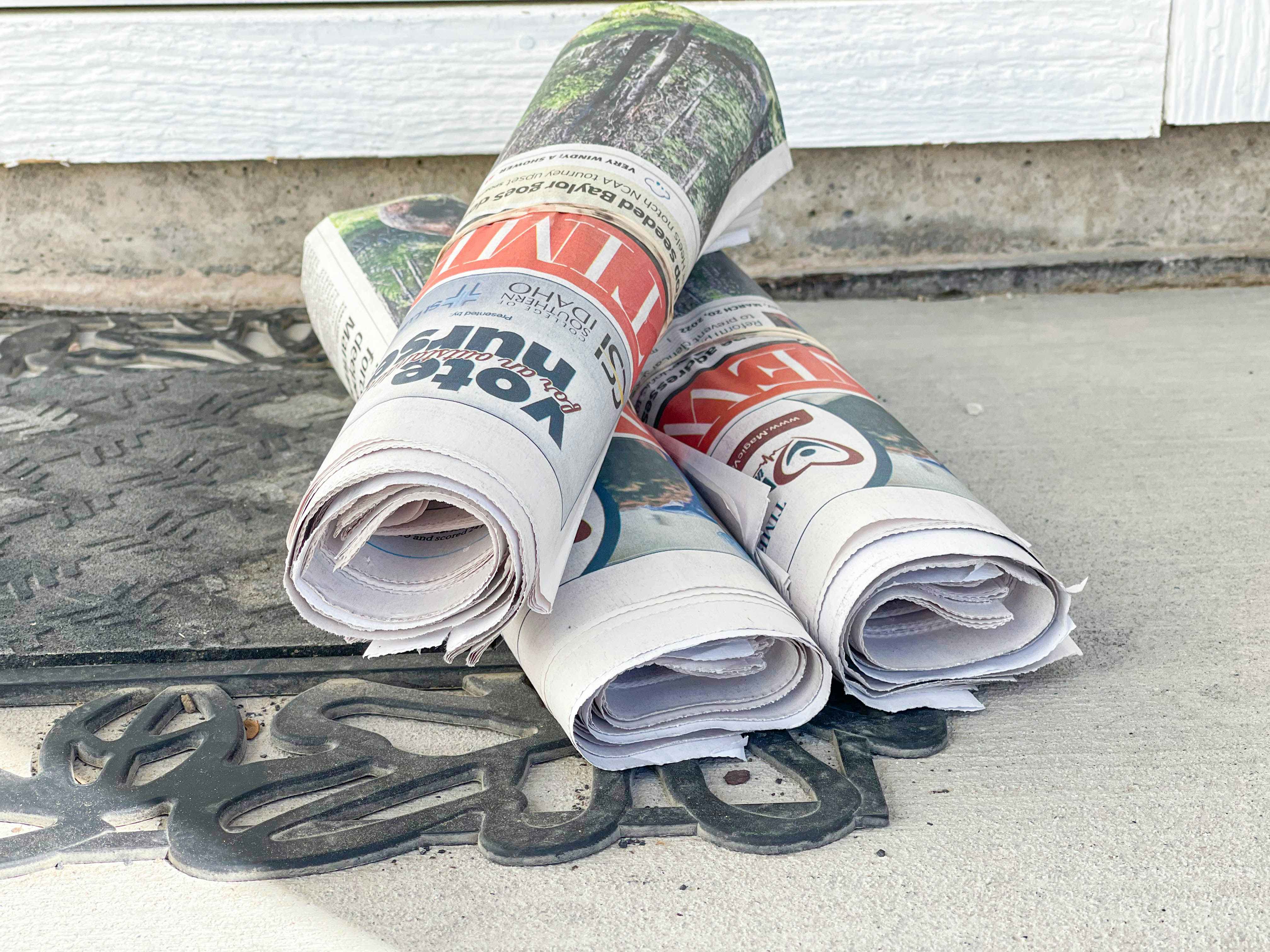 a person grabbing a newspaper from porch