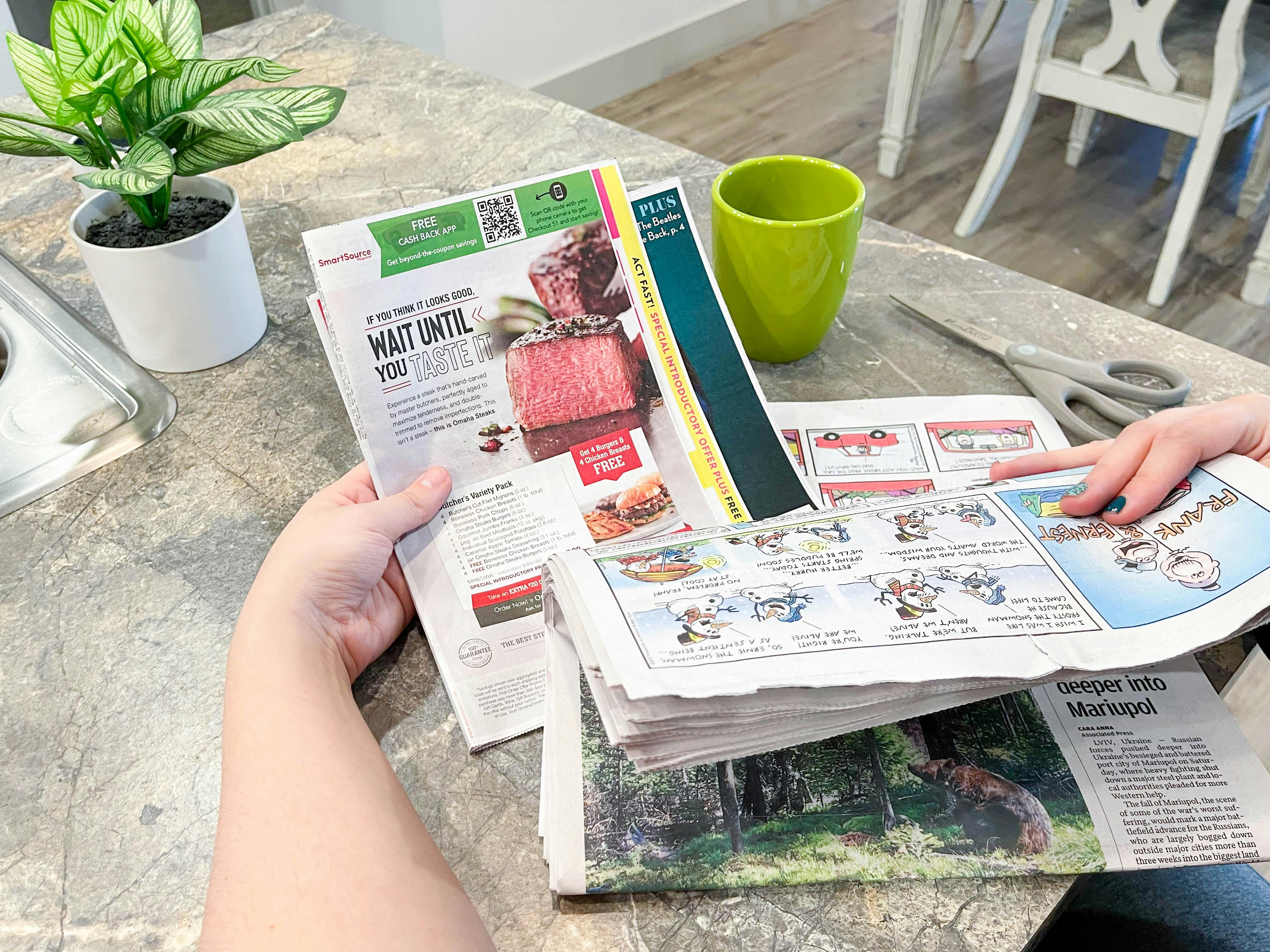 a person pulling a SmartSource coupon insert out of newspaper