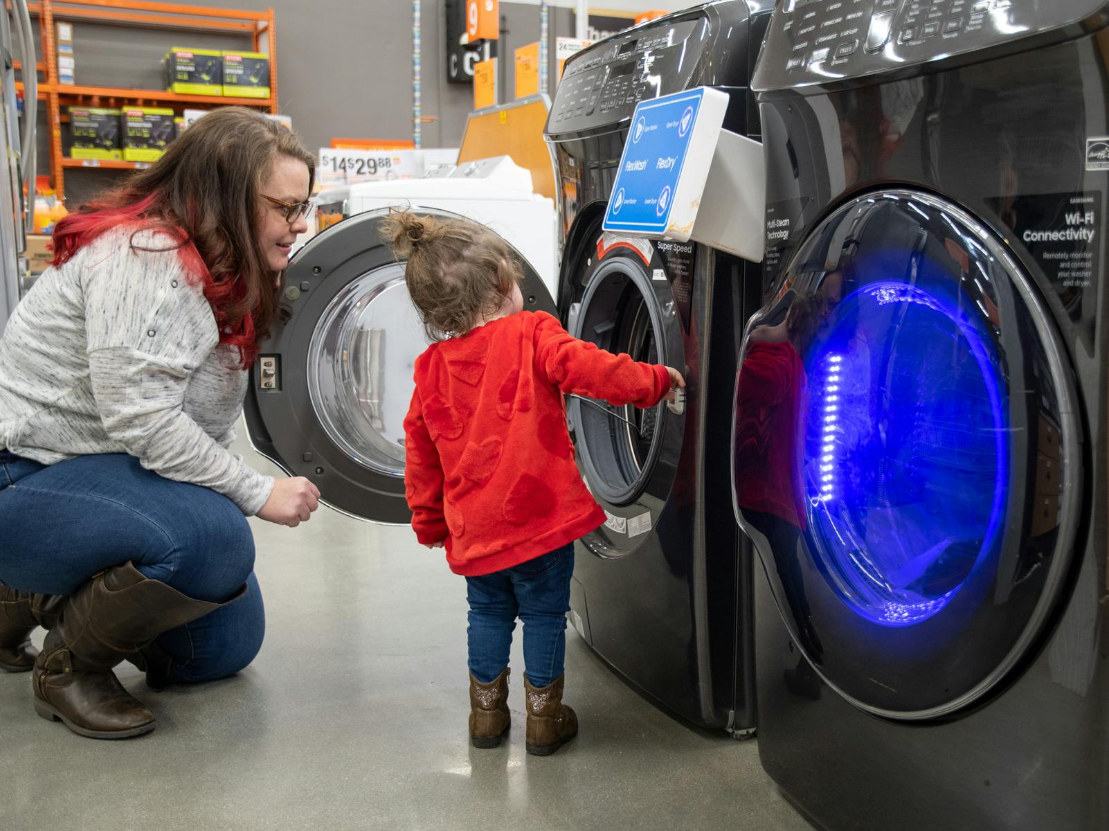 A mom and her child looking at a washer in Home Depot