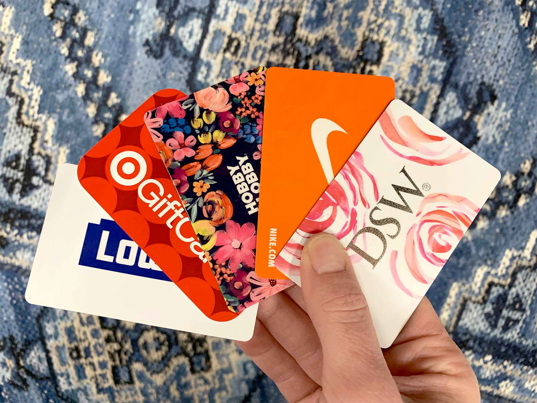 woman holding 5 gift cards