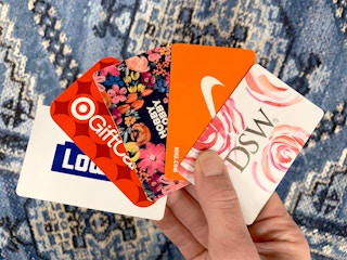 woman holding 5 gift cards