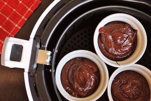 chocolate cake batter in ramekins set in an air fryer