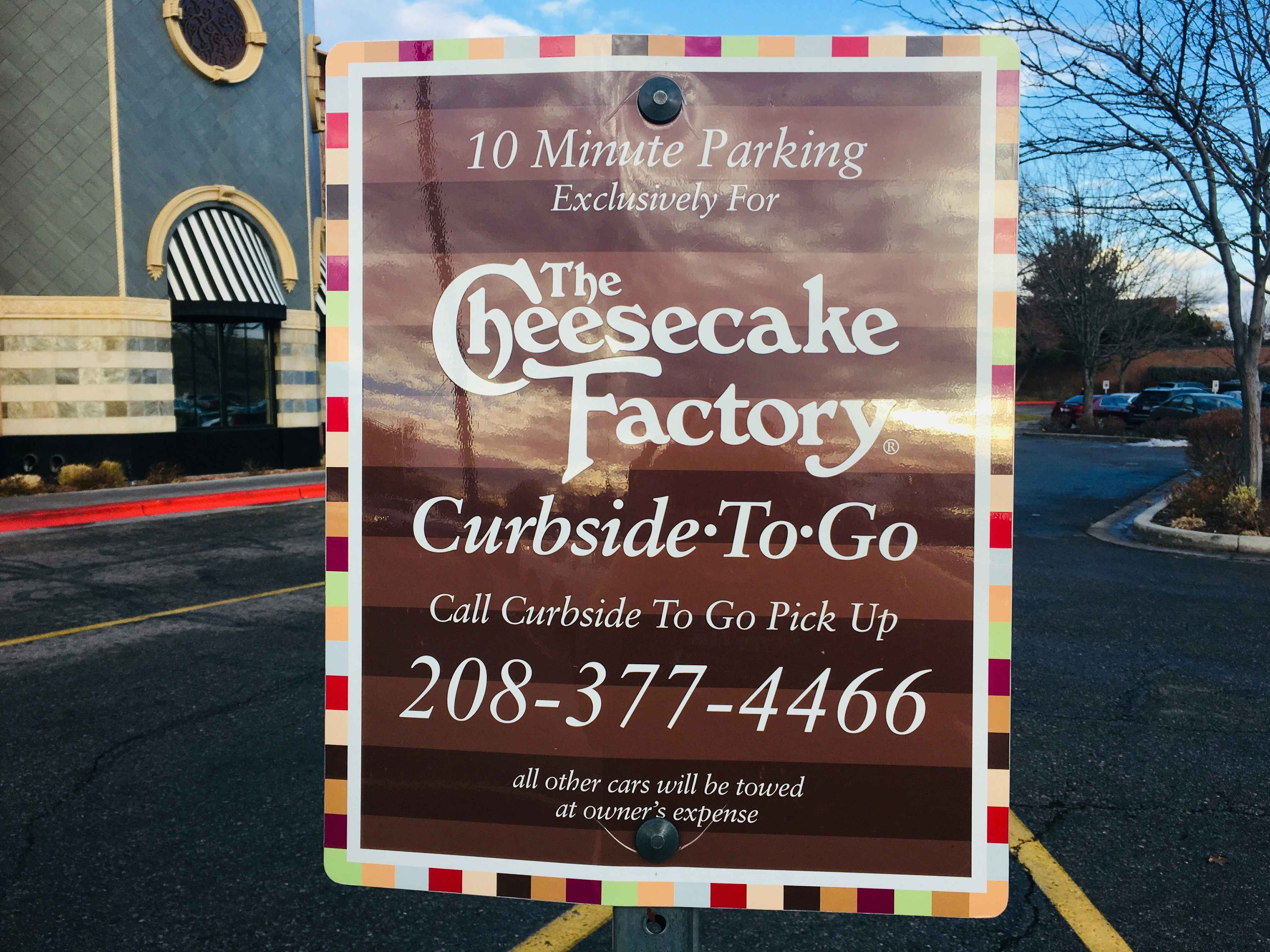 A 10 minute parking sign to designate the Curbside-to-go parking space outside of The Cheesecake Factory.